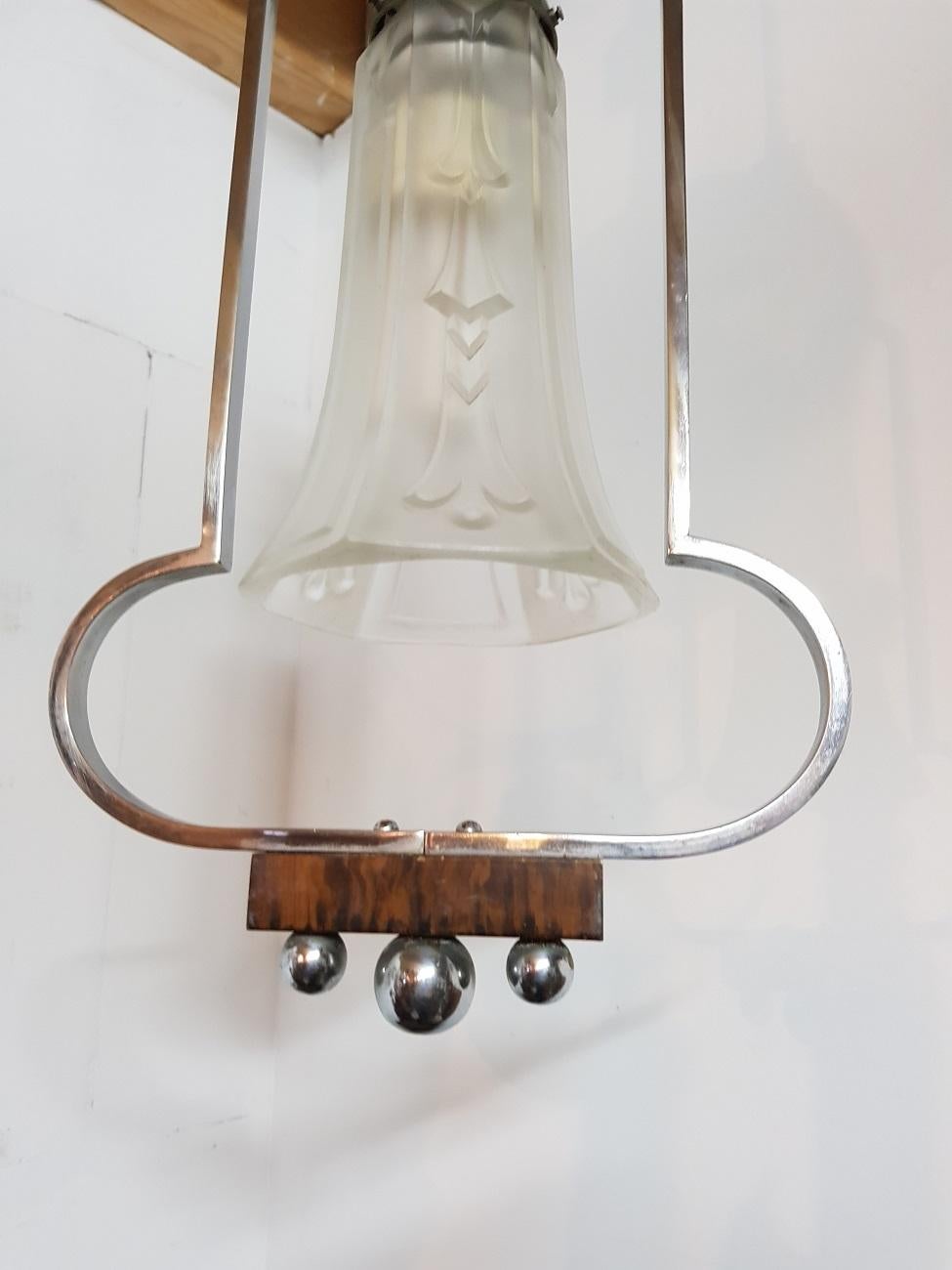 Art Deco partly chrome and wooden hall pendant with press glass shade, made in the 1930s and the wire and fitting is renewed.

The measurements are,
Depth 13.5 cm/ 5.3 inch.
Width 24.5 cm/ 9.6 inch.
Height 74.5 cm/ 29.3 inch.