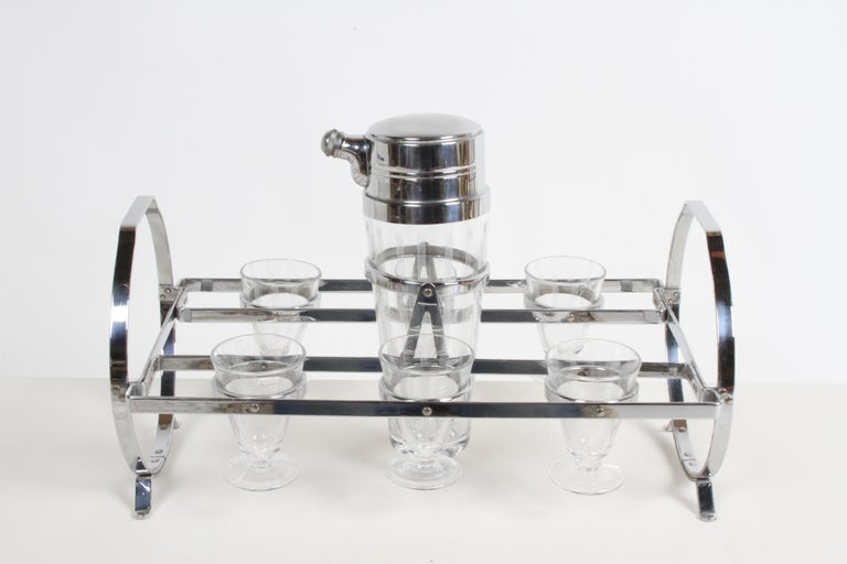 Fabulous period all original Art Deco or Machine Age Cocktail set barware set, consisting of tall etched glass cocktail shaker with chrome lid, matching etched drinking glasses on chrome Gyroscopic caddy or stand. In fine condition, with no damage