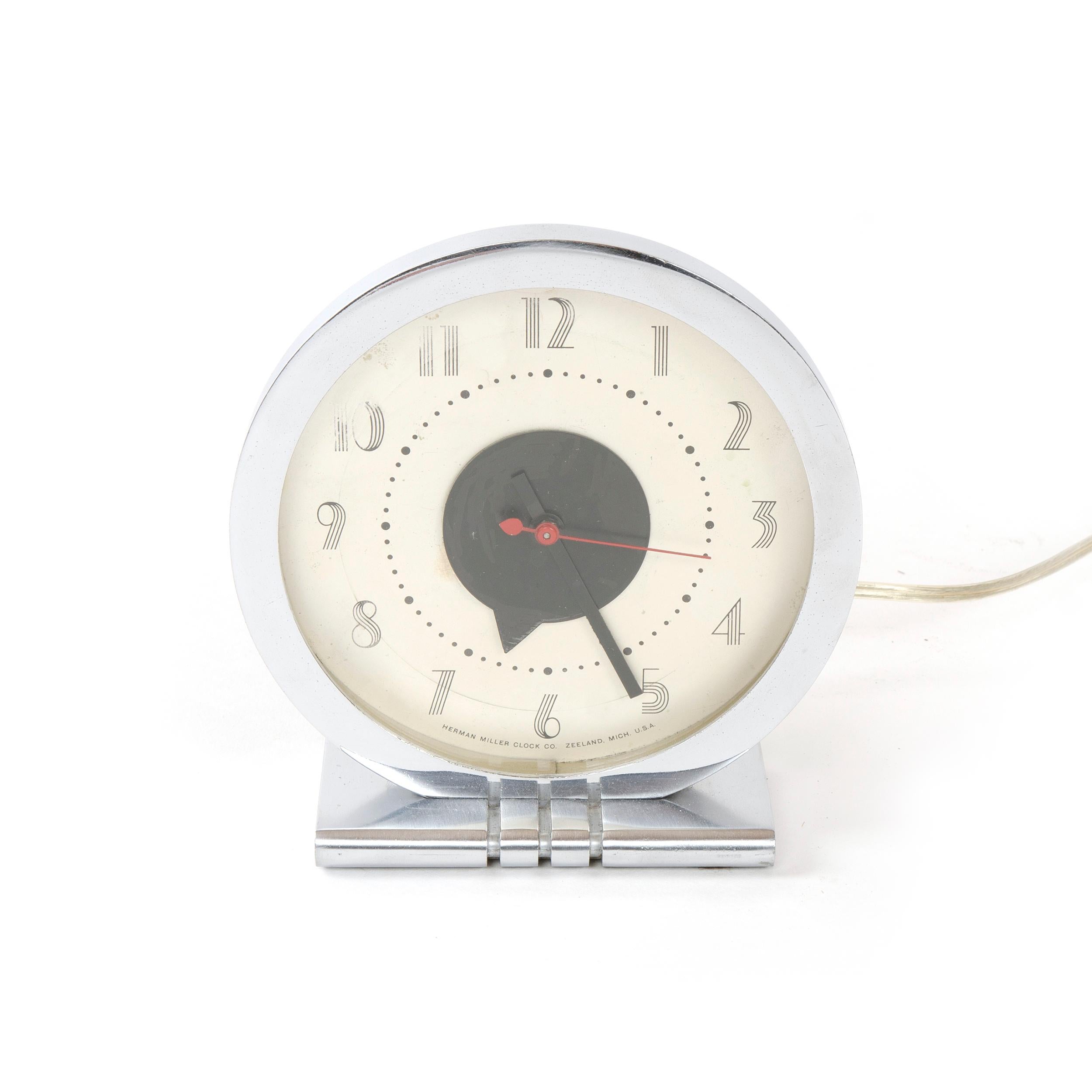 An electric chrome Art Deco clock with an ivory face and a red sweeping second hand.