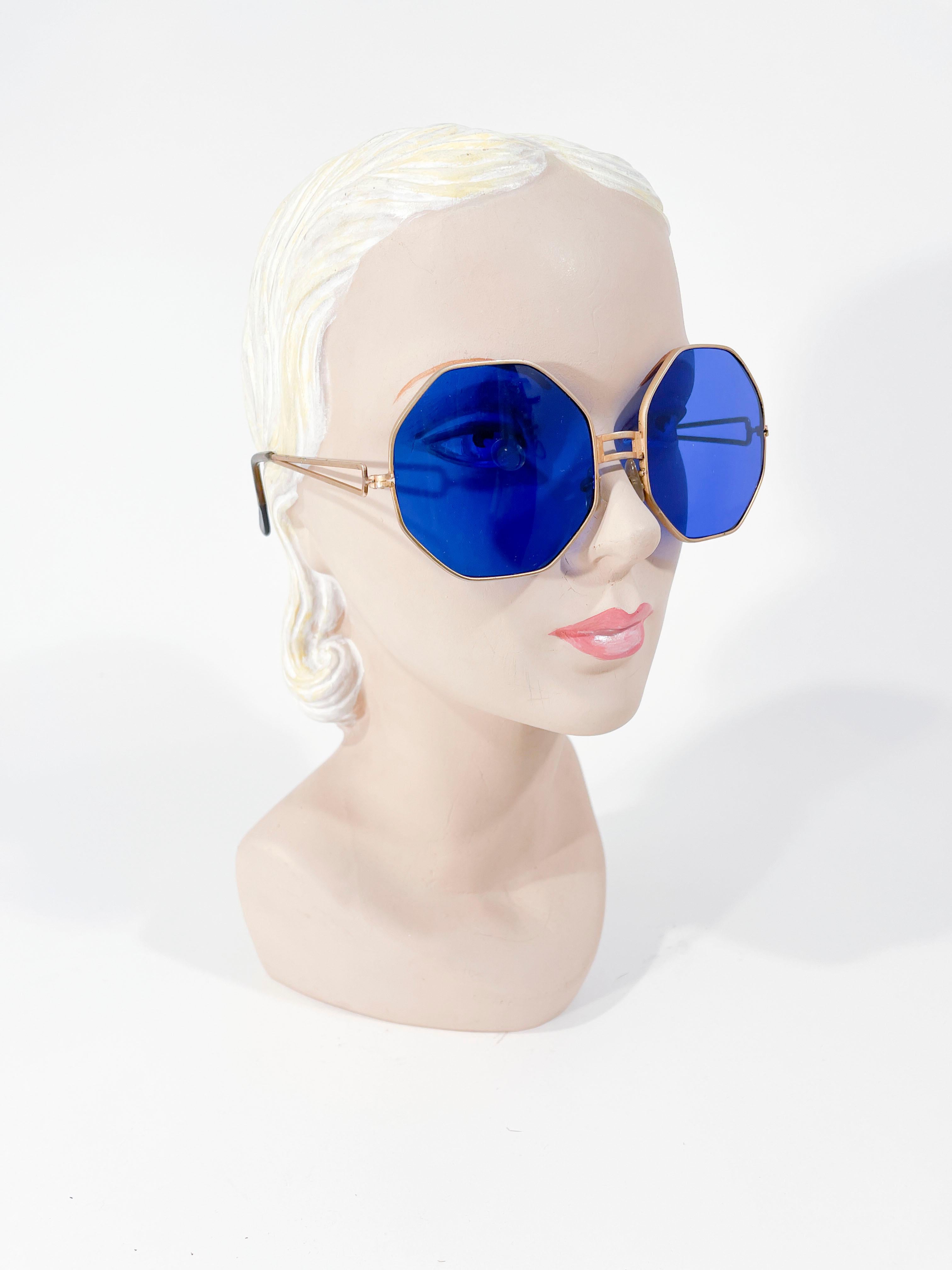 1930's Art Deco cobalt blue glass lensed sunglasses with brass frame and celliloid tipped arms. The lenses are oversized to capture the full frame of vision in the vivid blue shade. 