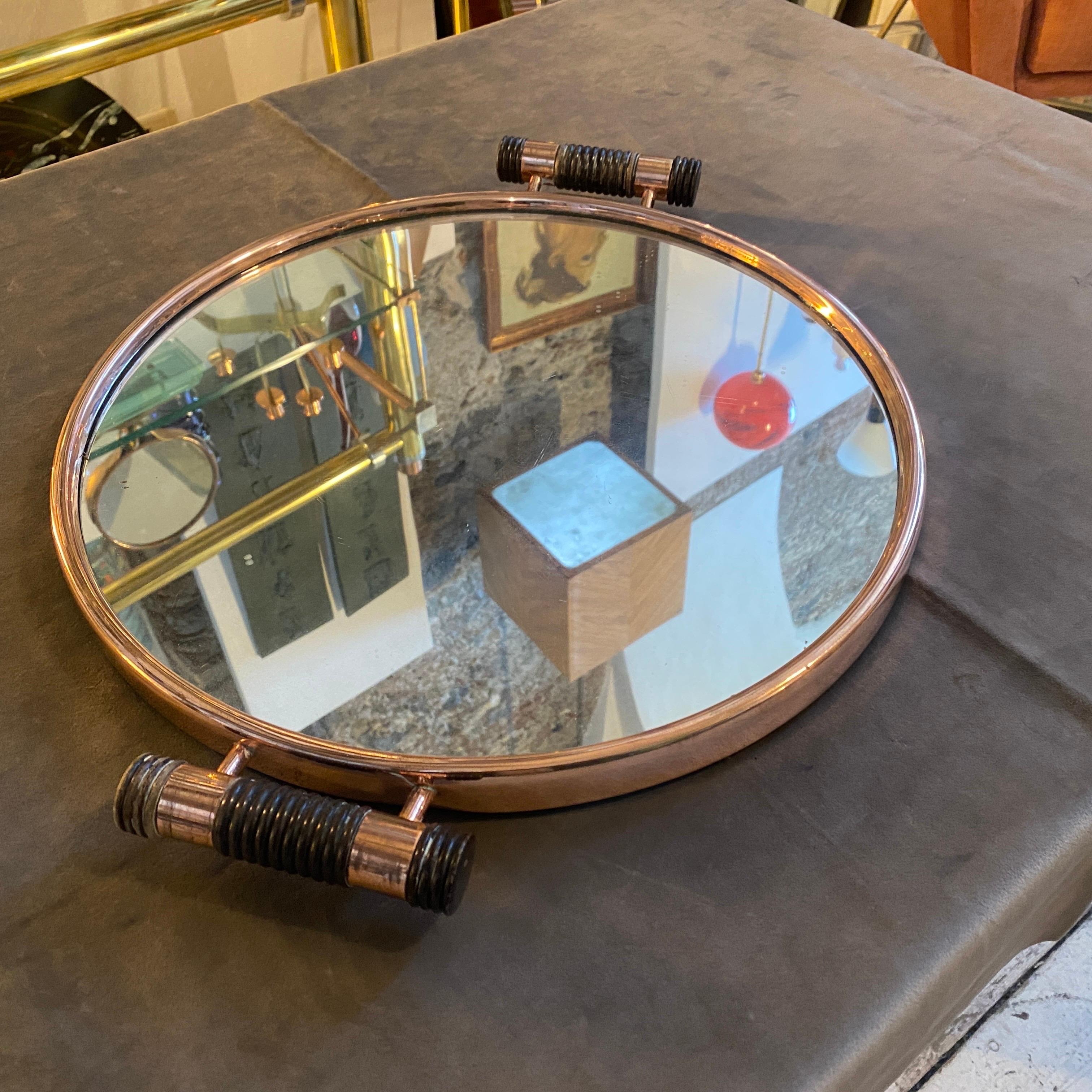 A stylish Art Deco round tray designed and manufactured in Italy in the Thirties. It's in a very good vintage condition. This Italian Art Deco round tray made of copper, mirror glass, and ebony handles is labeld on the bottom with original label of