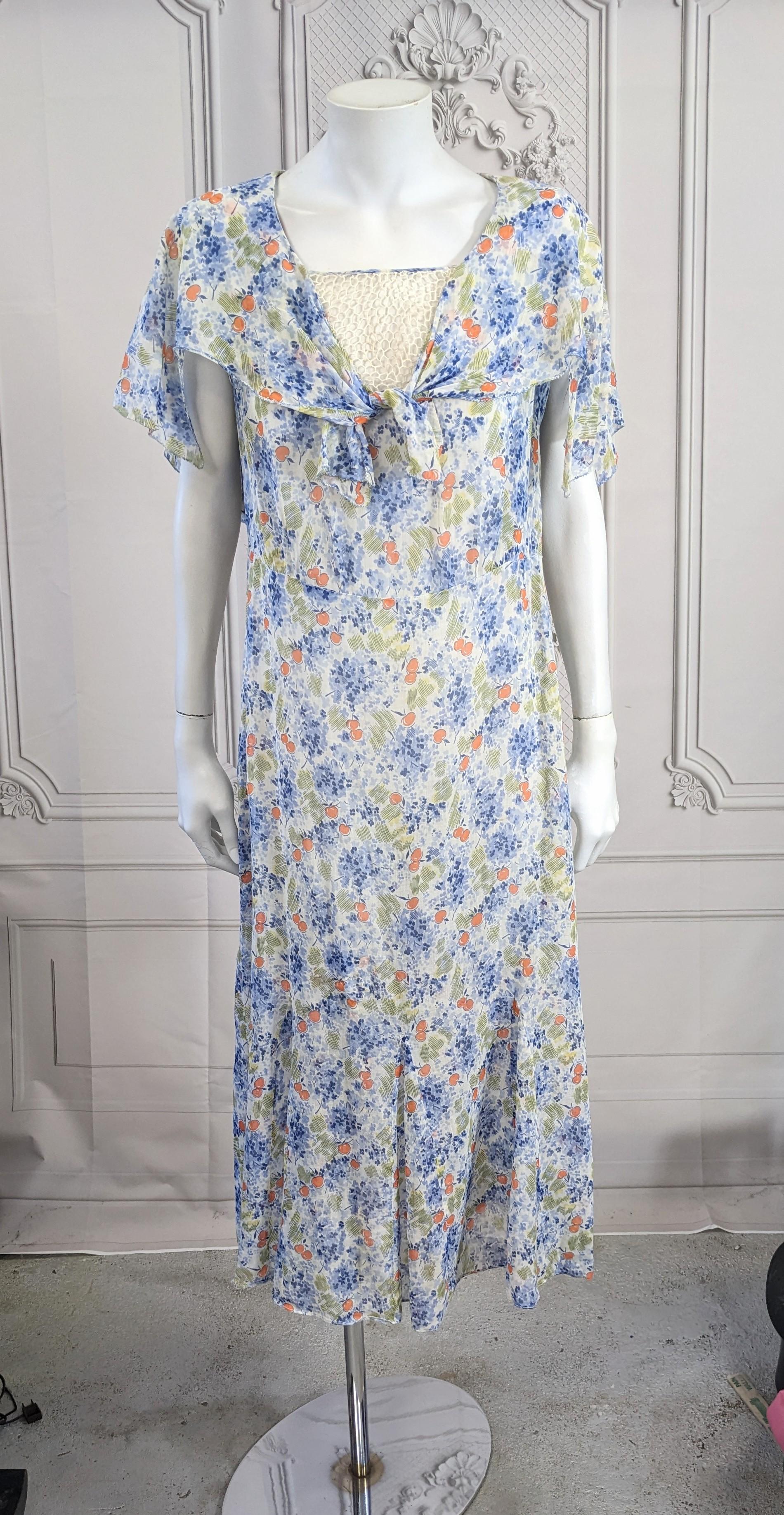 1930's Art Deco Cotton Cherry Print Day Dress mit fließendem Capelet-Kragen, der vorne gebunden wird. Am Halsausschnitt ist ein Spitzeneinsatz angebracht, der auf Wunsch aber auch entfernt werden kann. Charmanter Druck von orangefarbenen Kirschen