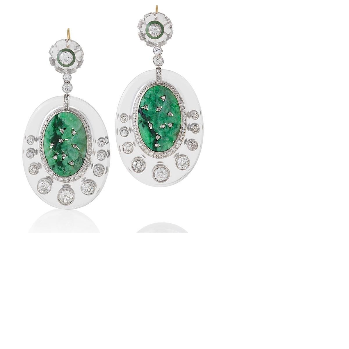 A pair of Art Deco platinum earrings with jade, diamond, enamel and rock crystal. The earrings have foliate carved jade centers, decorated and surrounded by 126 old European-cut diamonds with an approximate total weight of 6.60 carats. The carved