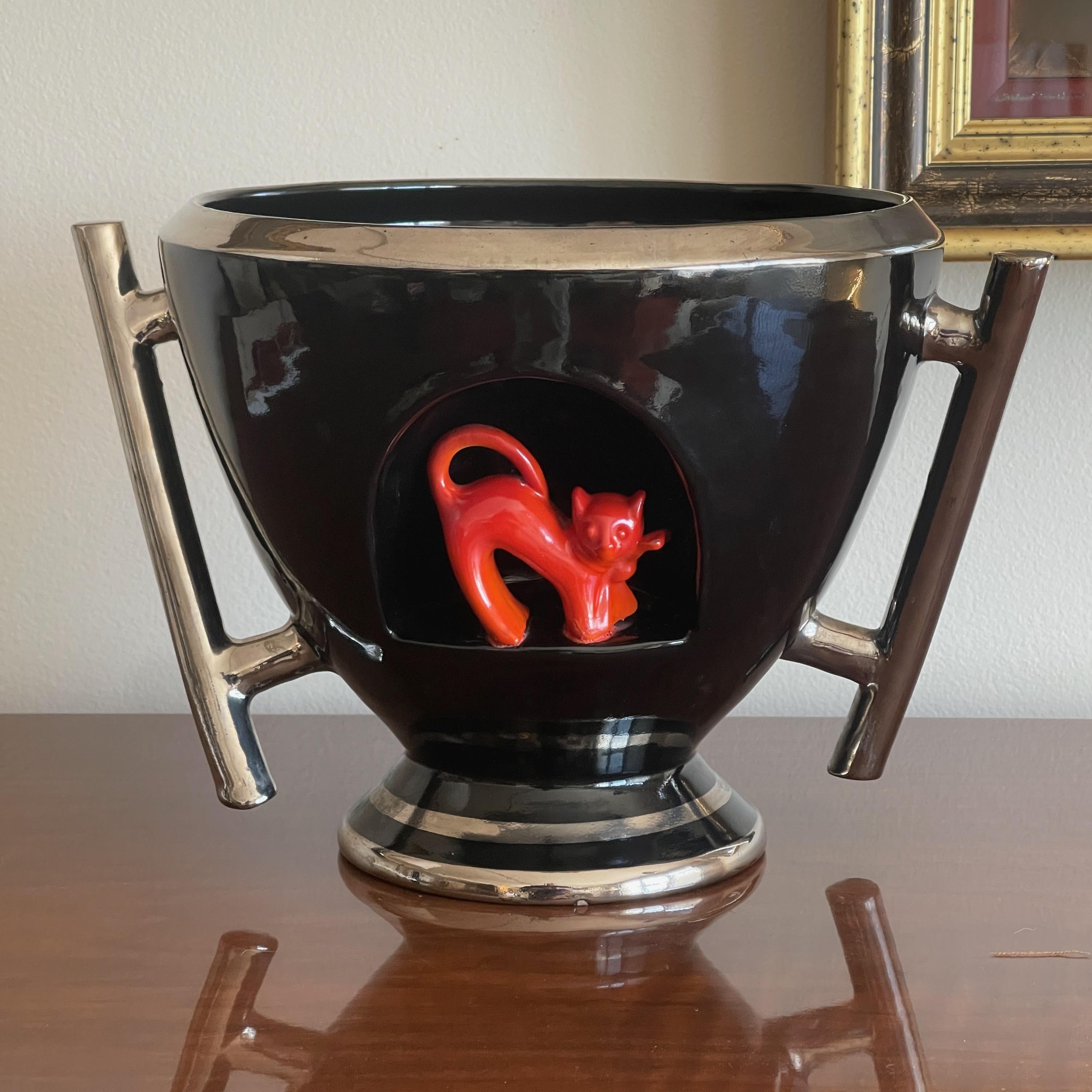 Rare 1930's Italian black glazed majolica urn with asymmetric handles which are silvered along with rim and foot and an orange glazed stylized fox set within an arched niche.
Designed by Ezio Cocchioni.
Signed underside 'Deruta'.
Documentation: S.