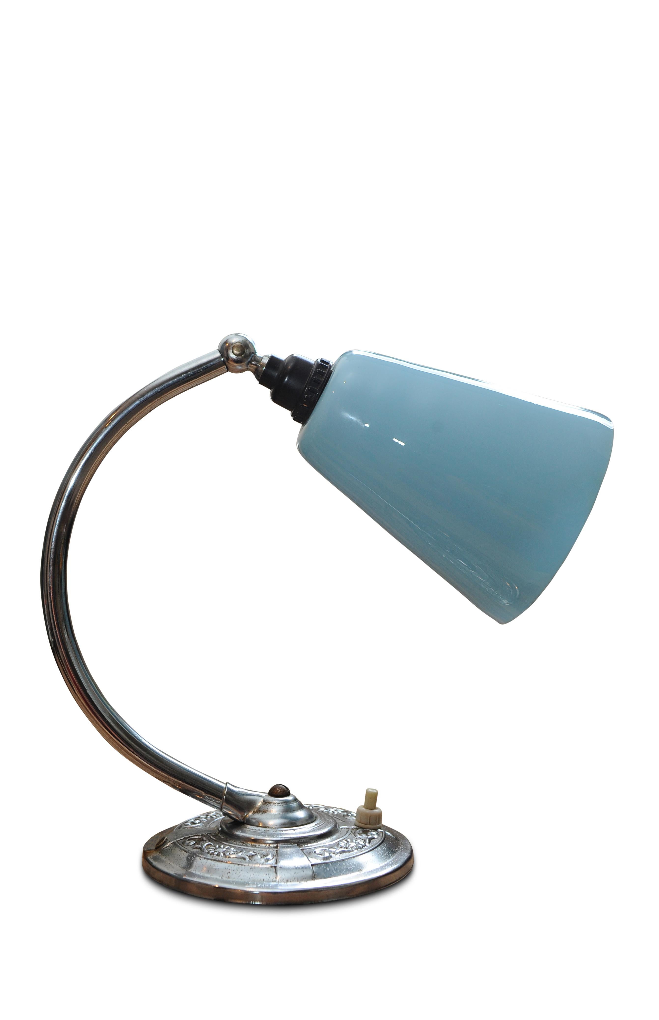 1930s Art Deco desk / table lamp, chrome base, chrome bend support & blue glass shade.
Shade is on a pivot so can be adjusted up and down.
Electrics have been checked and PAT tested to British safety standards.
