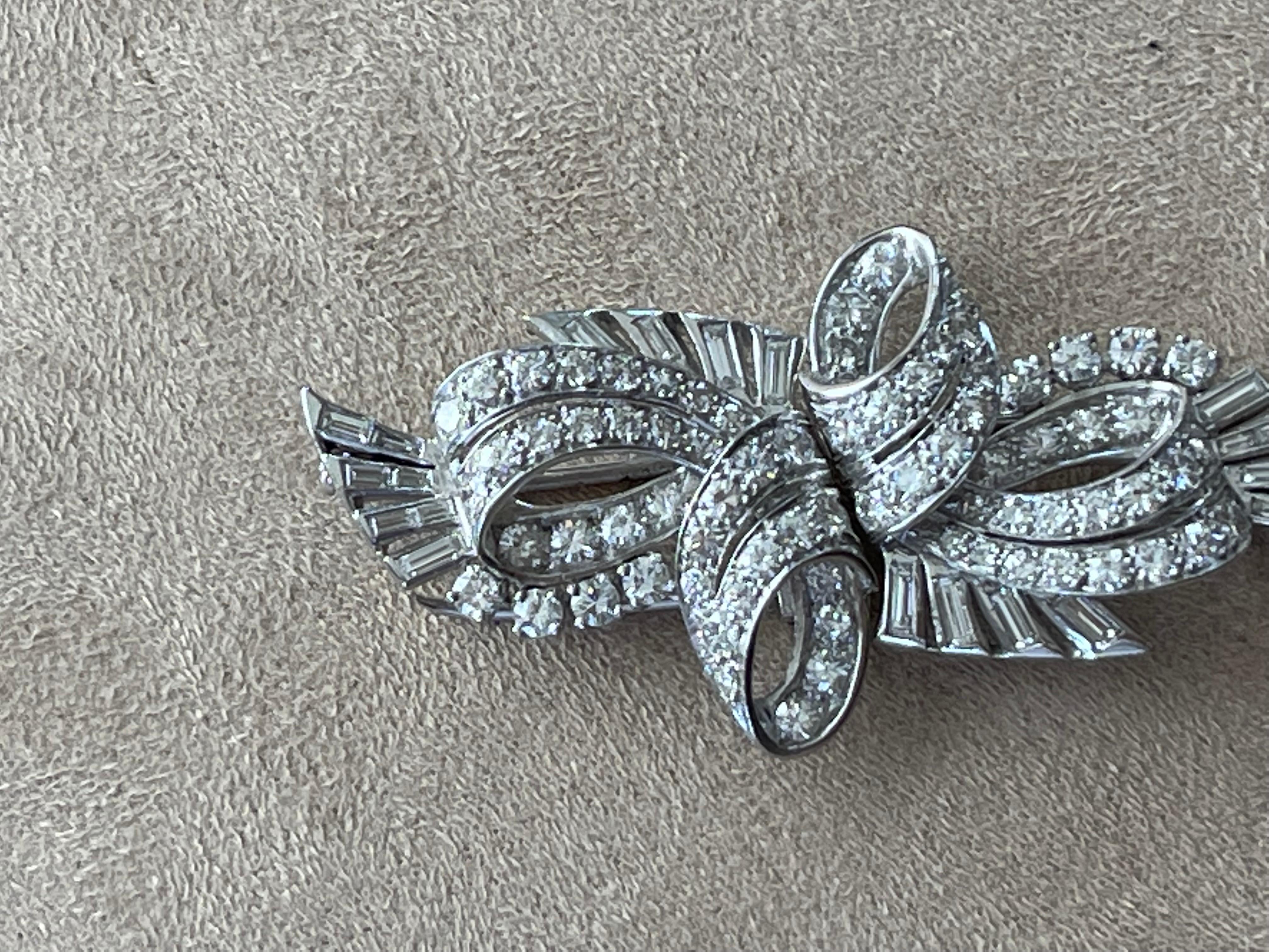 An Art Deco platinum and diamond double clip brooch featuring a stylized ribbon motif set with  old European-cut diamonds and baguette-cut diamonds with an approximate total weight of 6.00 ct, VS clarity,  H/I color grade. Circa 1930's. 
Masterfully