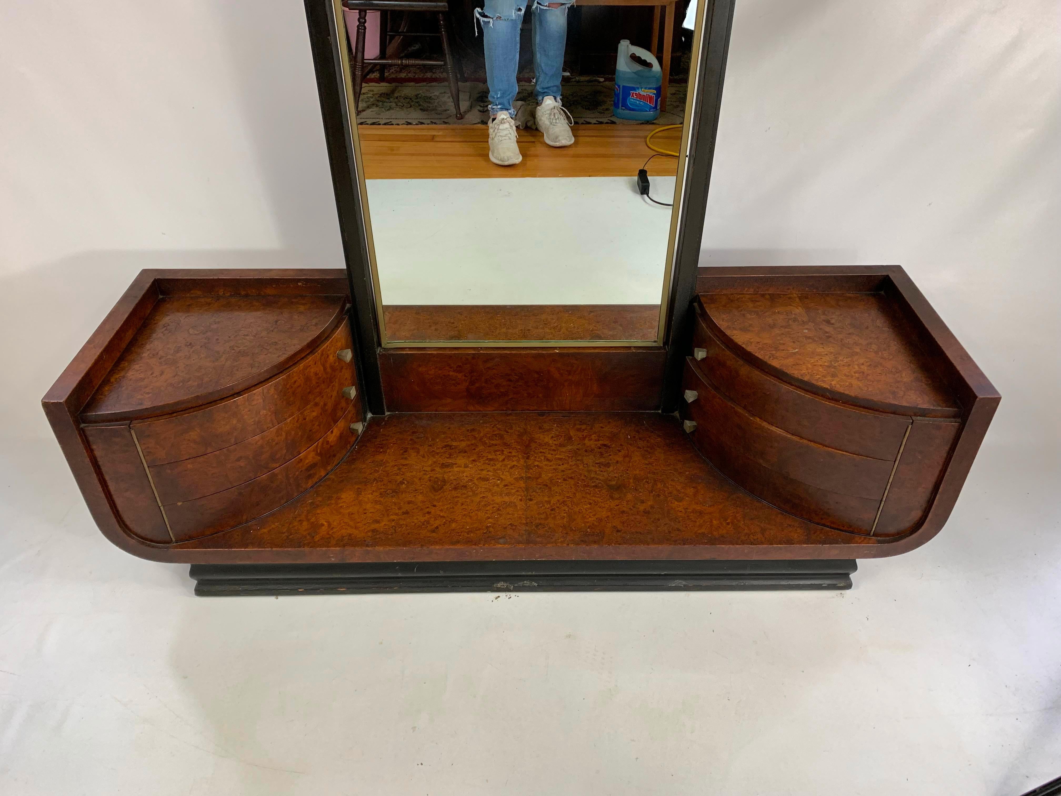 This stunning machine age Art Deco vanity was realized by the esteemed 20th century luminary- Donald Deskey- who designed the iconic Radio City Music Hall. The vanity features a demilune body with a Carpathian elm. The base is supported by A black