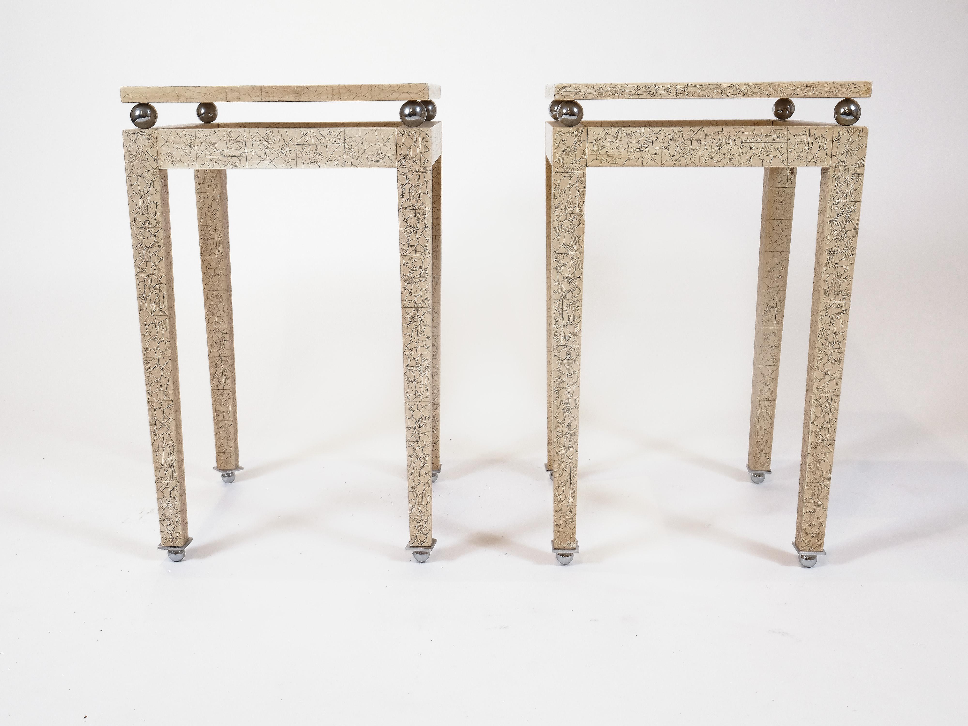 Angeboten wird ein Paar von Art Deco Eierschale und Lack Beistelltische. Die Massivholzoberfläche der Platte und der Beine ist vollständig mit Eierschale in Cremeweiß mit schwarzem abstraktem Motiv lackiert, und jede Ecke ist an einer Metallkugel