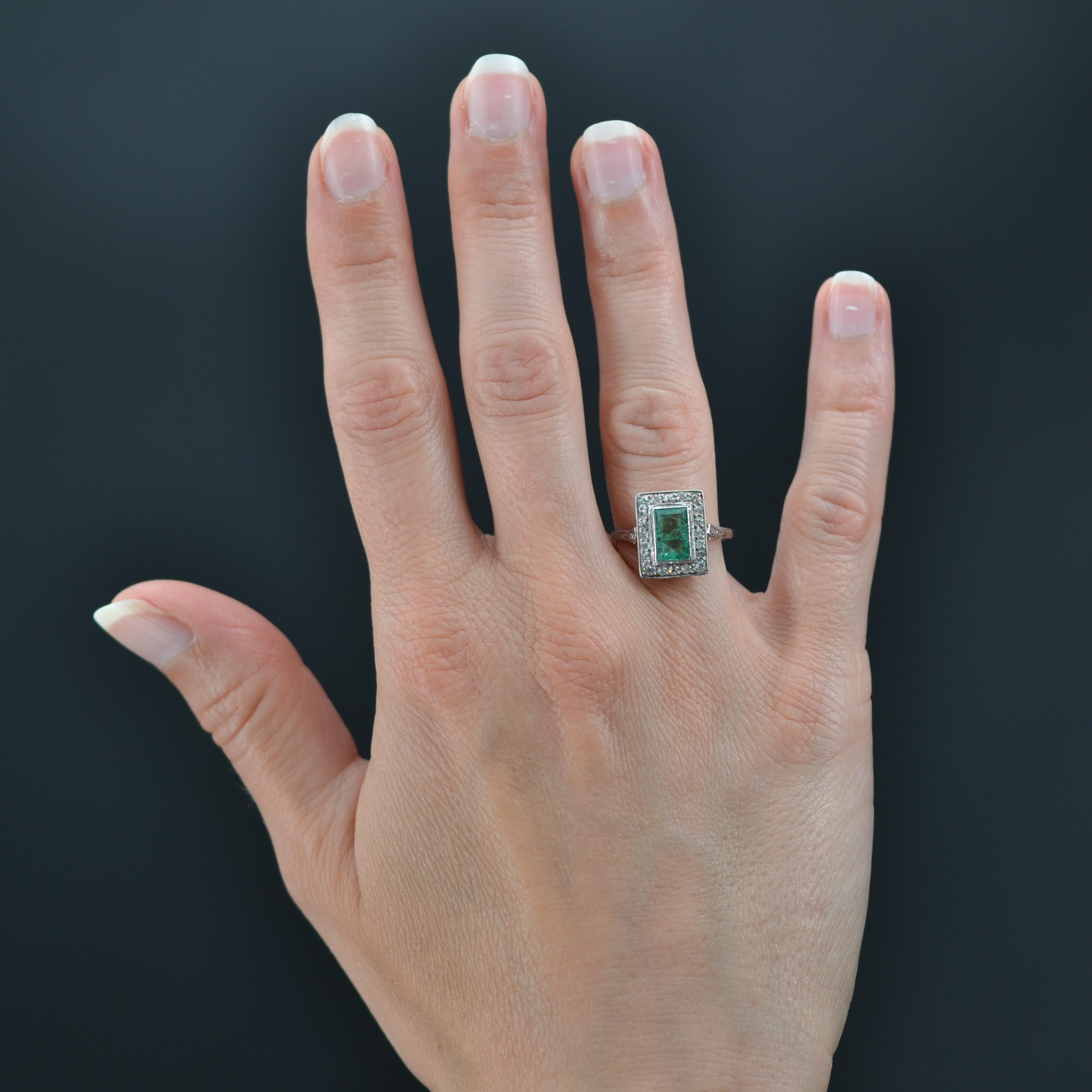 Ring in platinum.
Its geometric and flat setting is set with a millegrain- cut emerald in a setting of antique- cut diamonds. The basket is openwork and, on either side of the head, on the start of the ring, are set 2x1 rose-cut diamonds on an