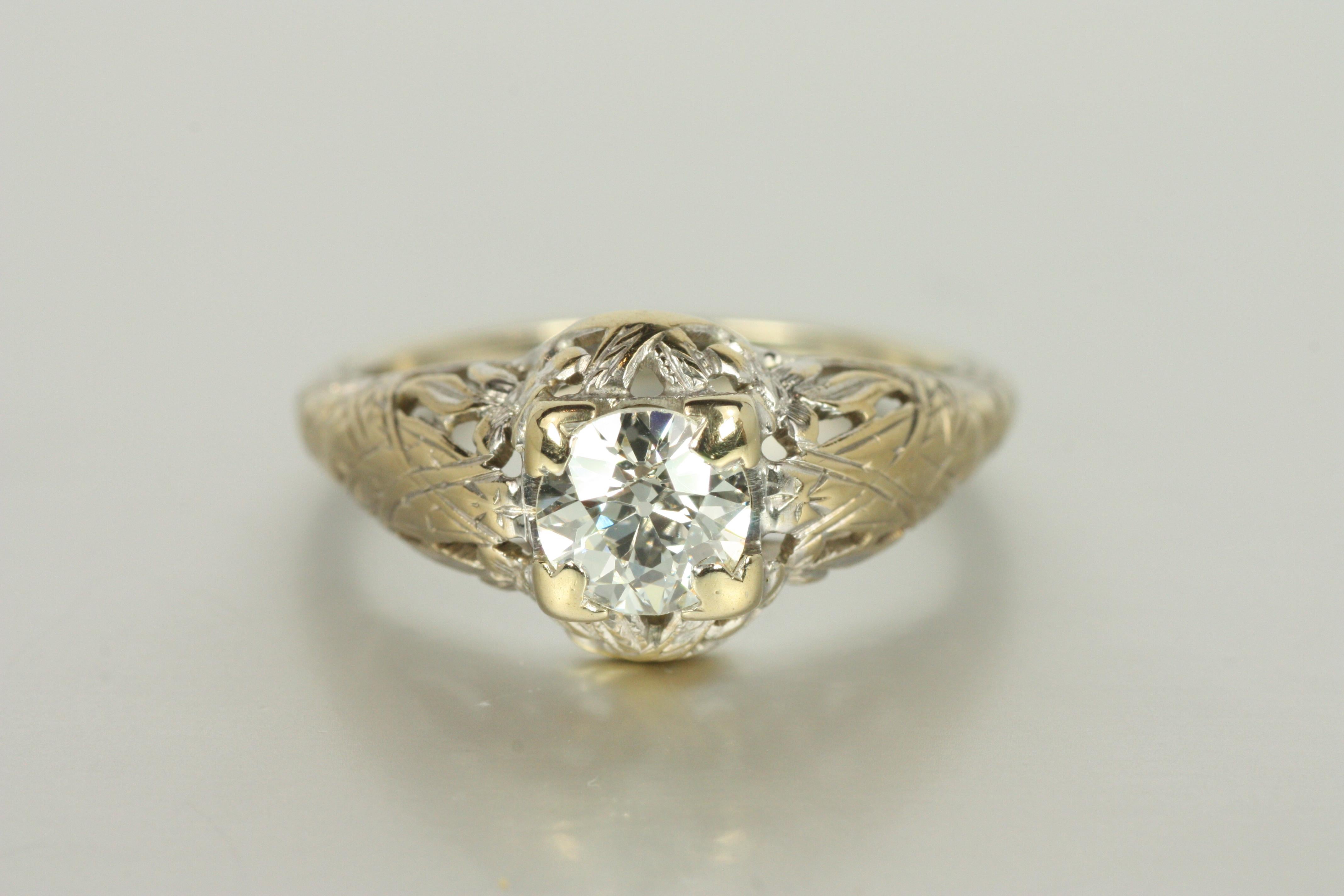 Timeless and intricate, this 1930s Art Deco antique solitaire engagement ring features a 0.60ct old European cut diamond, framed by an 18K white gold filigree setting with floral hand engraving. A delicate yet bold statement, this piece embodies the