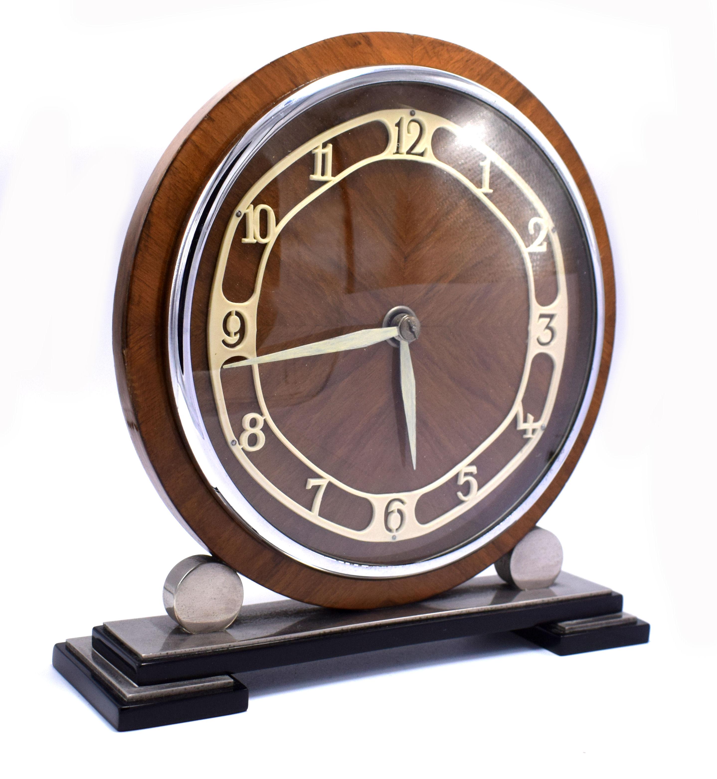 Very attractive 1930s Art Deco clock with an eight day movement. Originating from England this very attractive case has a mid tone figured walnut dial which acts as the back drop to the cream enamel fretted out numerals and chrome bezel. All of