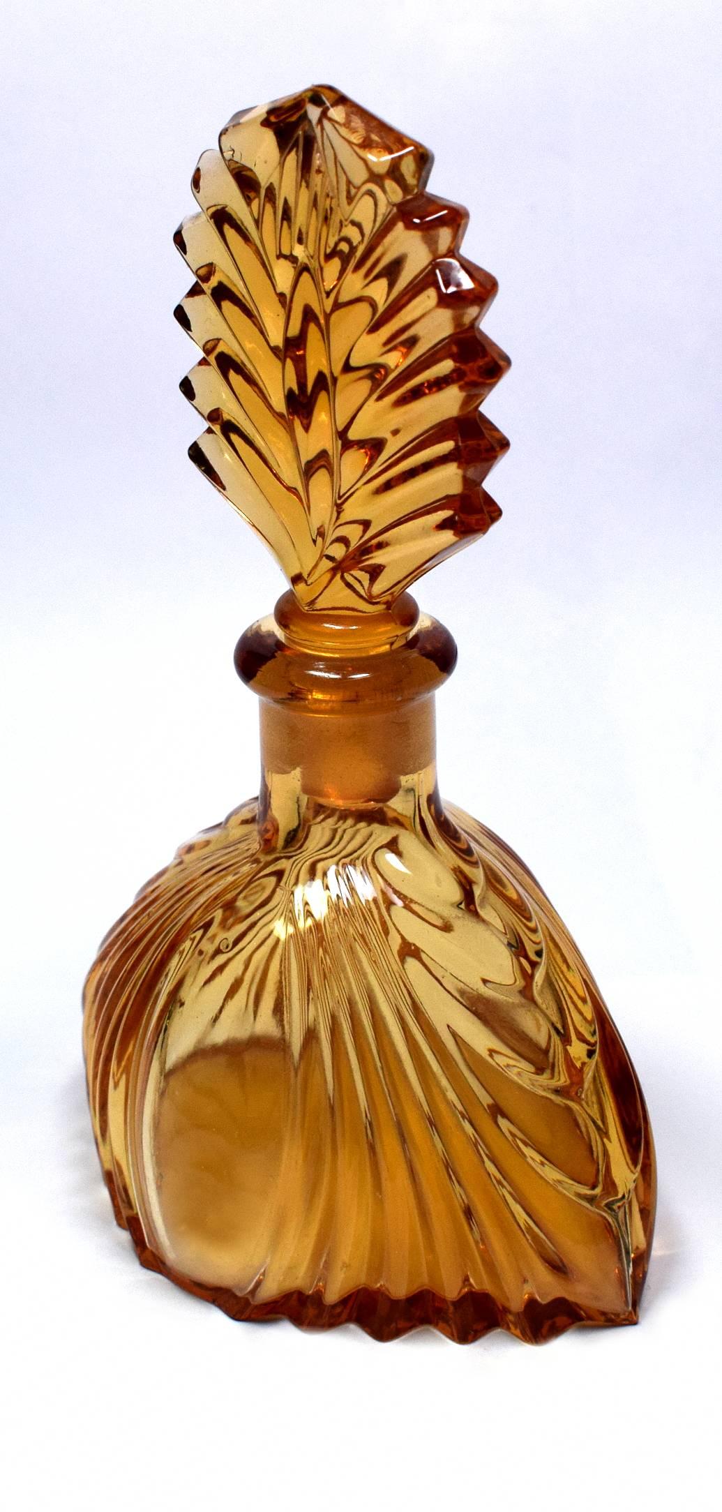 A really beautiful amber and clear colored Art Deco perfume bottle with a wonderful fan shaped glass stopper. In excellent condition with no chips or signs of use at all. A real collectors item for your Art Deco setting.