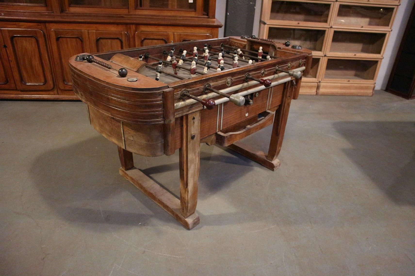 This piece is really out of the ordinary.
 It is raised on stylized lyre-shaped end supports. This French beechwood, walnut and formica table has got metal players. It is raised on stylized lyre-shaped end supports. Coin operated.
It is a