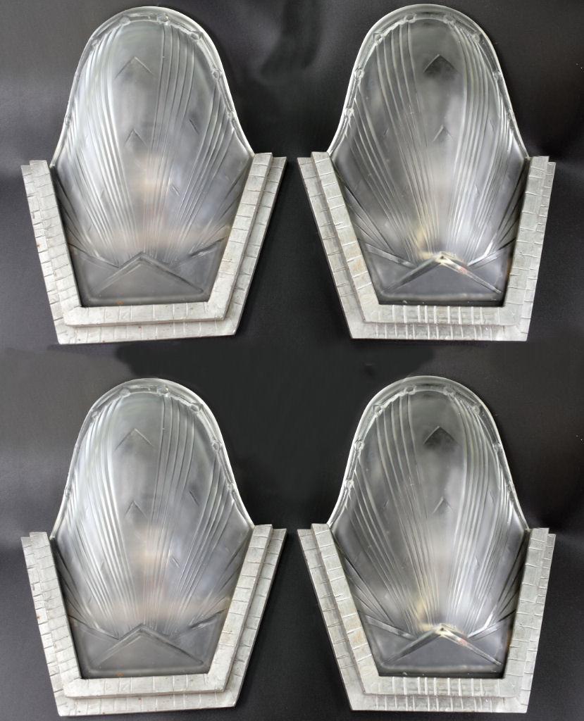 Original 1930s Art Deco set of four glass wall light sconces. The satin glass slip shades sit snugly inside heavy wrought iron wall brackets with a single bulb holder behind. These give a fabulous effect when lit against the wall. Really stylish set