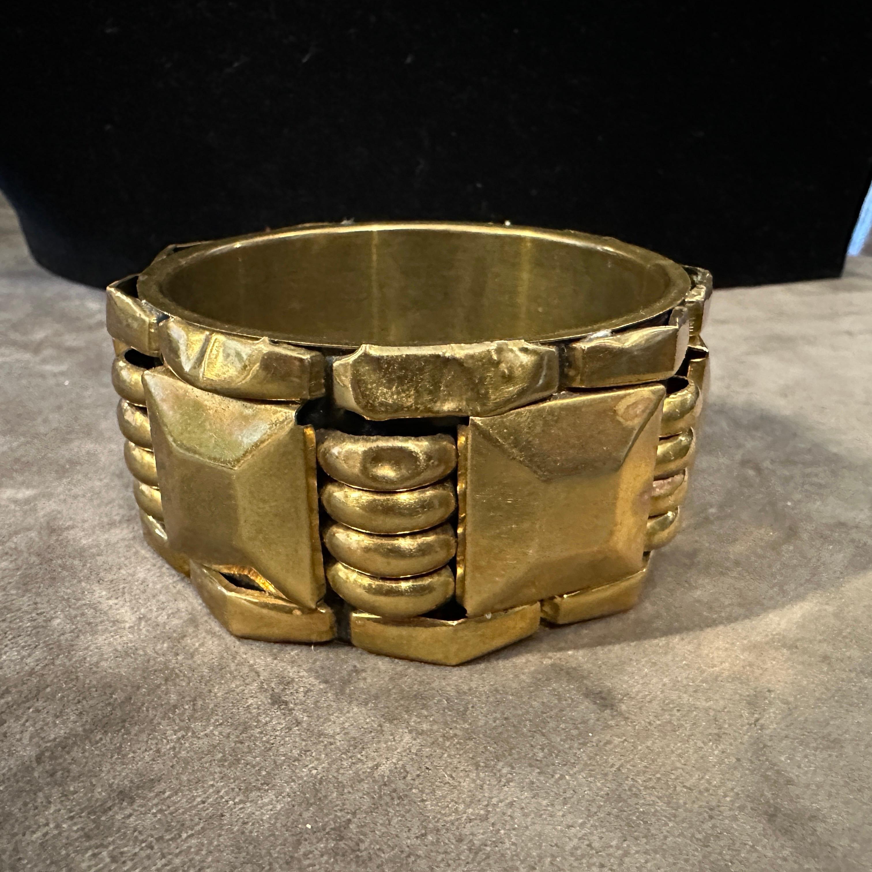 1930s Art Deco Gilded Metal Architectural Bangle Bracelet
Transport yourself to the opulent and geometric world of the Art Deco era with this stunning 1930s bangle bracelet. Crafted from gilded metal, this piece is a magnificent example of the