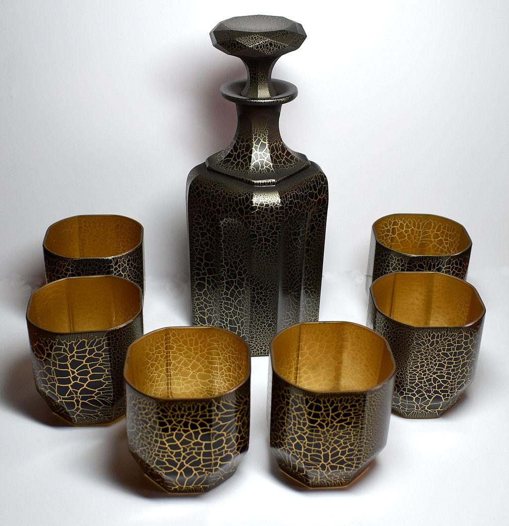 Art Deco decanter set dating to the late 1920s-1930s made in the Czech Republic. This set features a large impressive decanter with six matching shot glasses. The whole set is deeply etched with enamelled crocodile effect pattern which has then been