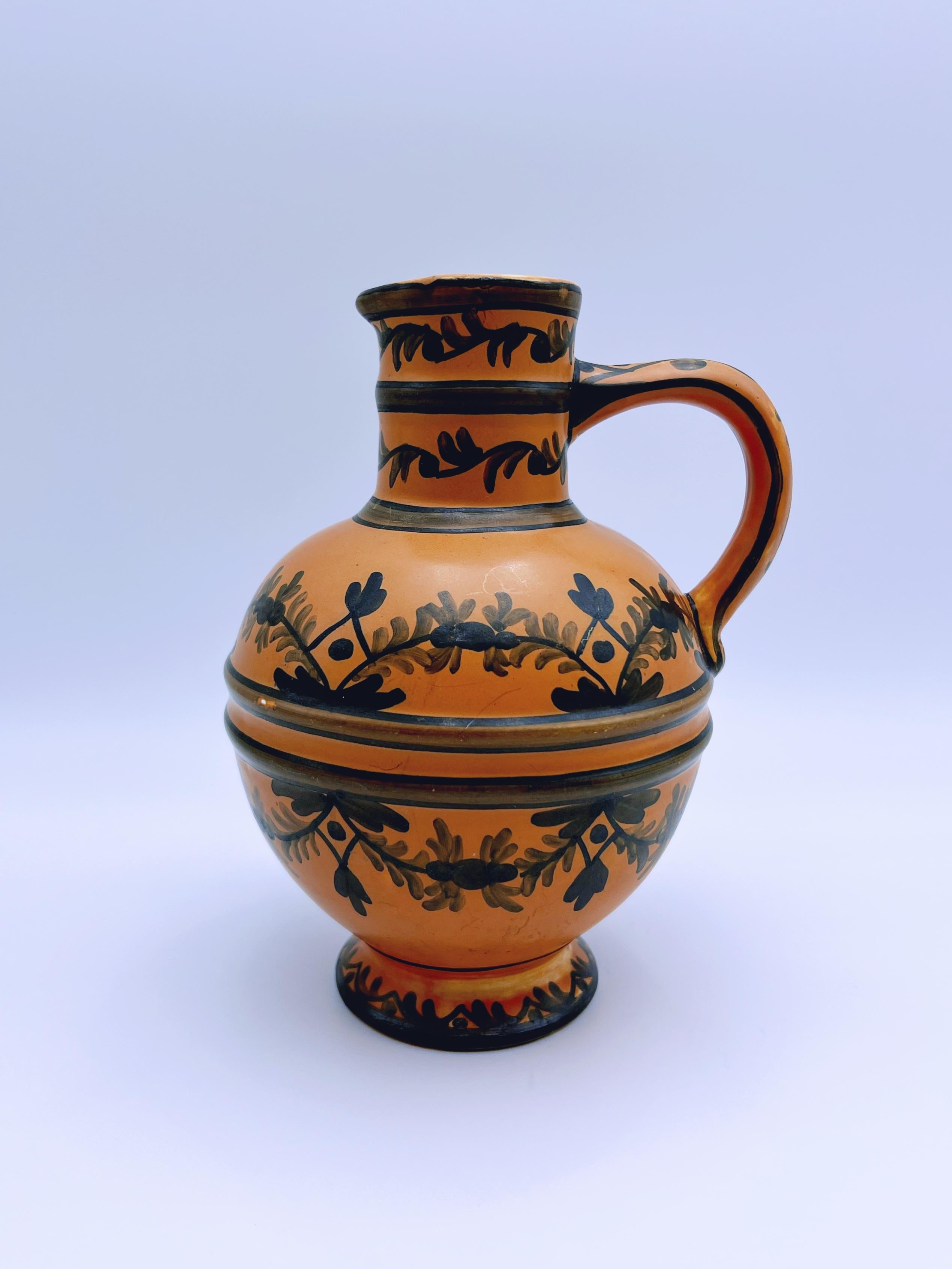 Vase pichet antique de style Art déco, de conception scandinave/nordique primitive, en faïence avec un motif sous-glacé peint à la main. Fabriqué par Egersund Faience en Norvège, vers les années 1930.

La forme élégante de ce vase en fait un ajout