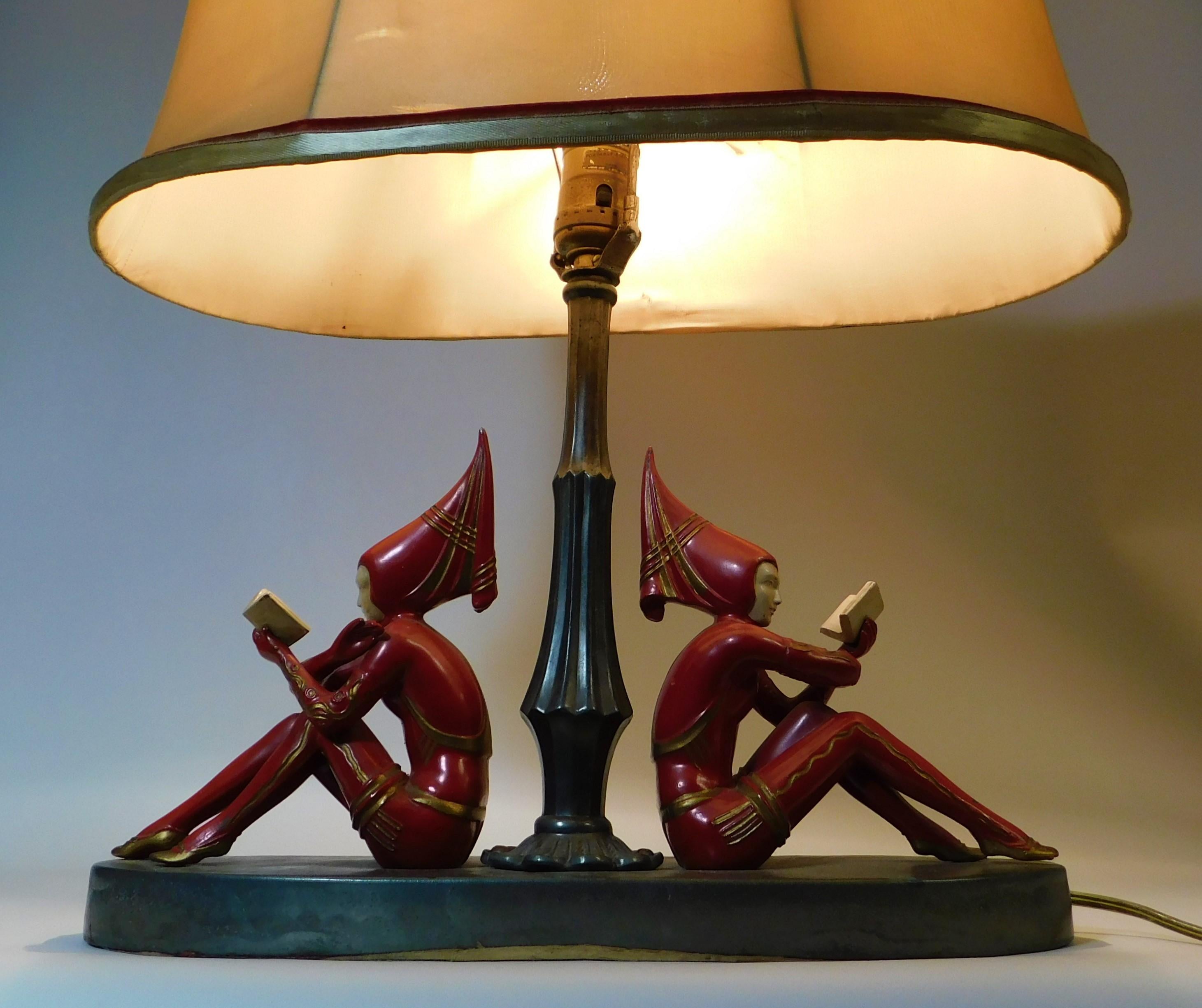 American 1930s Art Deco Harlequin table lamp with J.B. Hirsch, Erte or Gerdago girl Pixie red figures reading books, designed after Russian ballet dancers. Original shade with the base metal being spelter/poly-chrome/white metal work. Very rare to