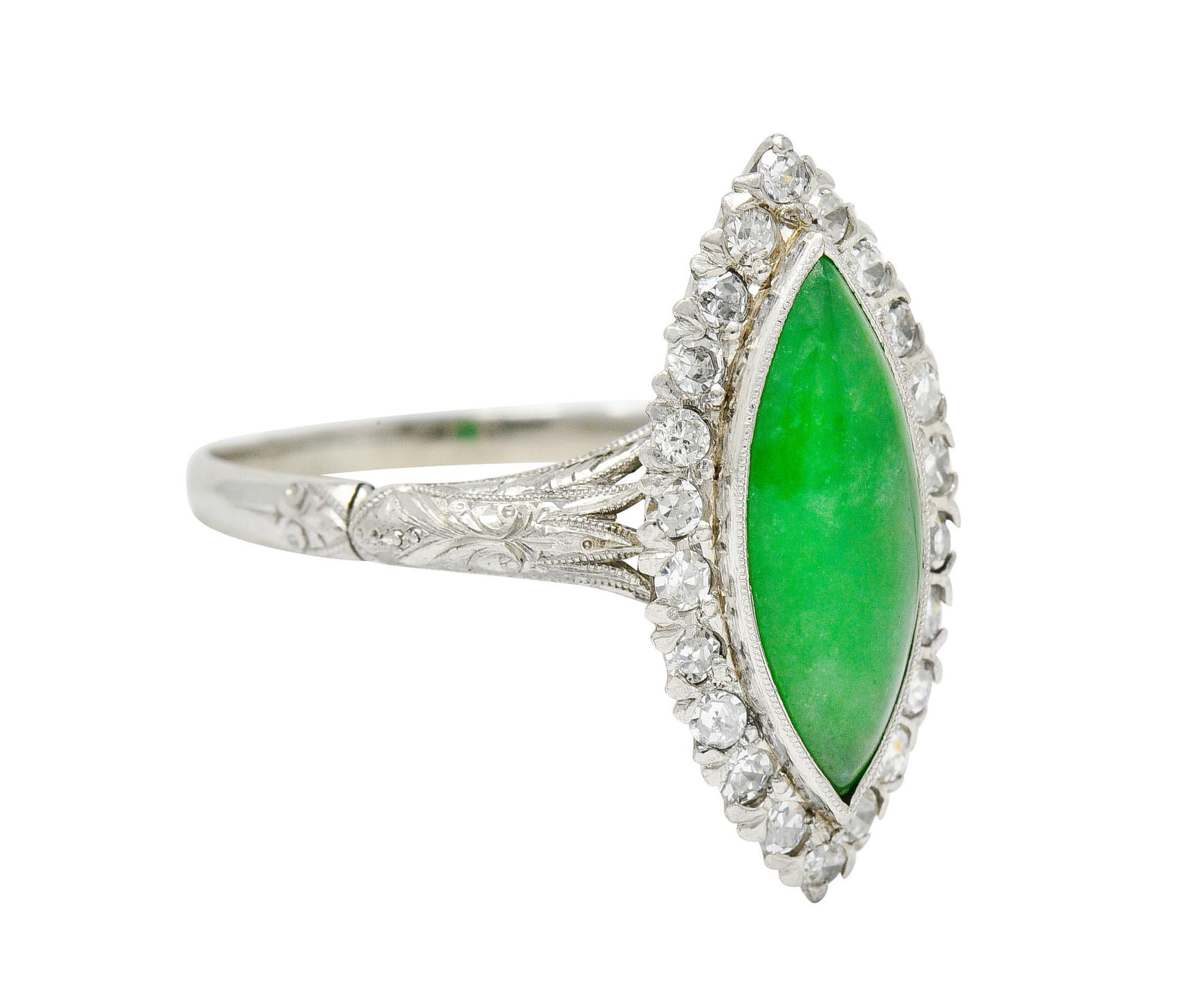 Cluster ring centers a bezel set navette cabochon of jade - measuring approximately 14.5 x 5.8 mm

Translucent with strong green color and subtle mottling

Surrounded by a halo of single cut and round brilliant cut diamonds

Weighing in total