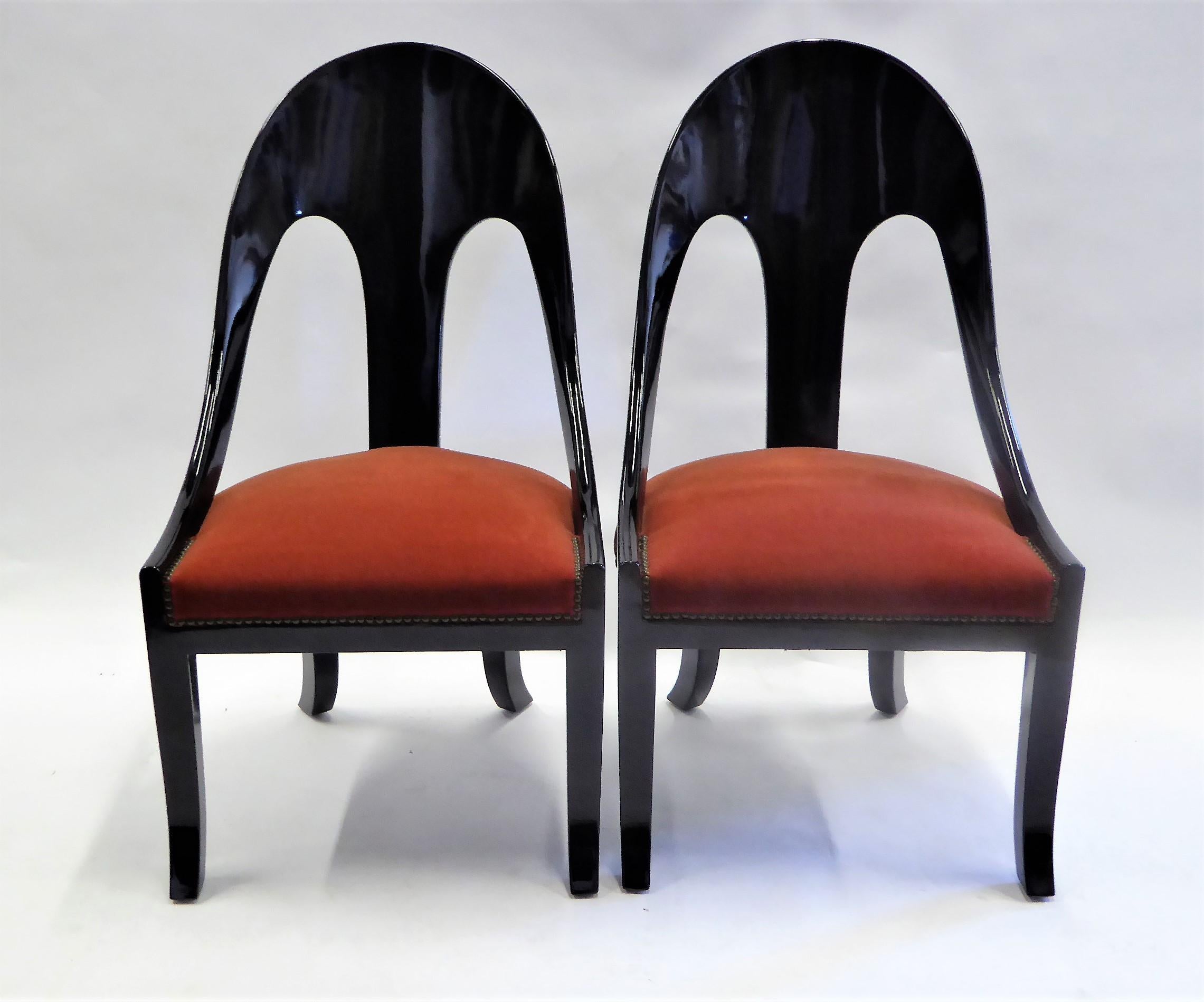 Period 1930s spoonback chairs with saber legs and a klismos bend, this pair of chairs are an elegant statement. Richly lacquered and with a deep burnt red Mohair velvet and nailhead upholstery, restored.
Measurements: 21 1/2 inches wide x 21 inches