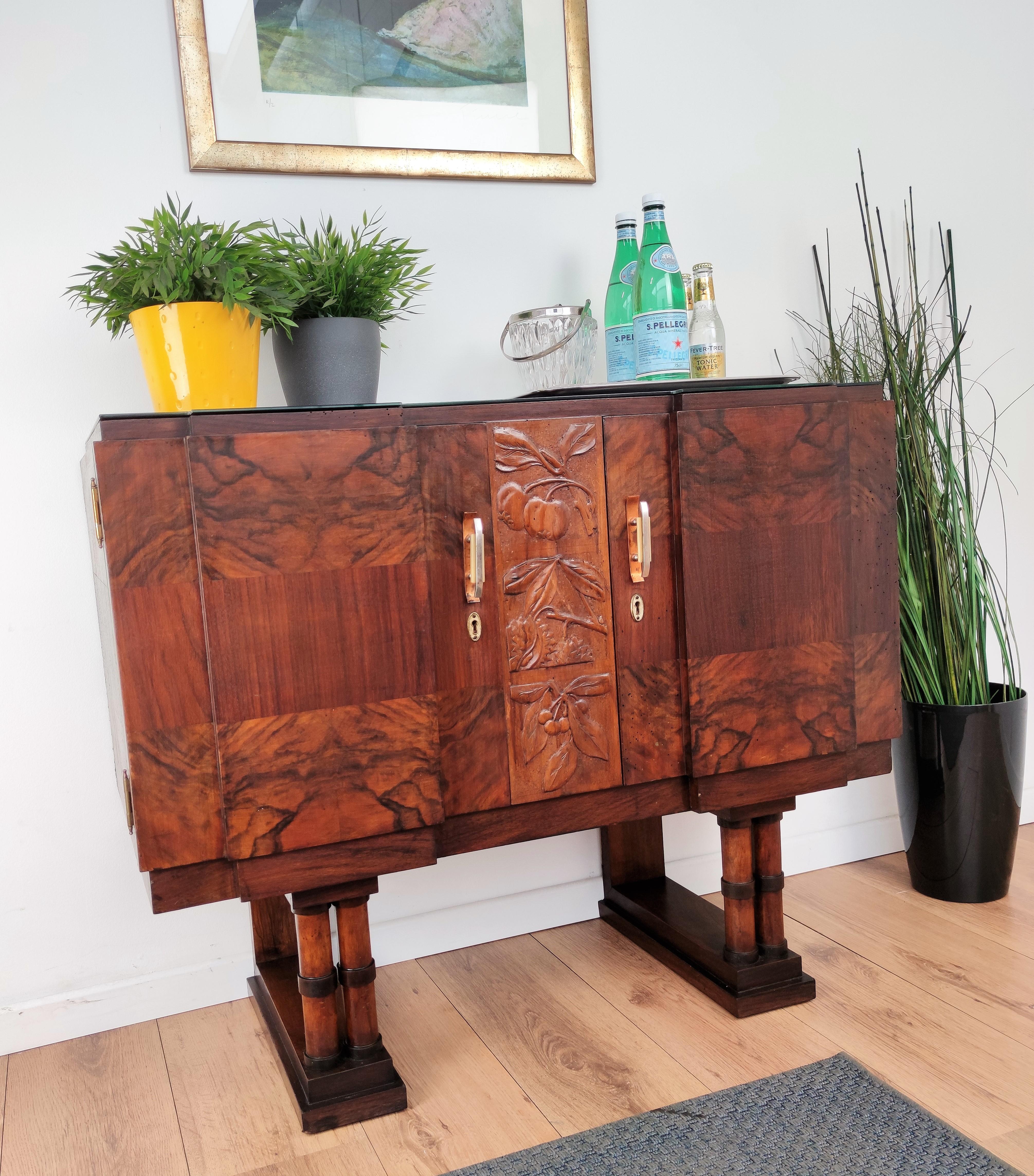 Beautifully shaped, decorated and crafted Italian Art Deco sideboard credenza bar cabinet, in walnut and burl, with great decorative use of the veneer and central crafted decor, two doors with antique brass door handles, standing on greatly crafted