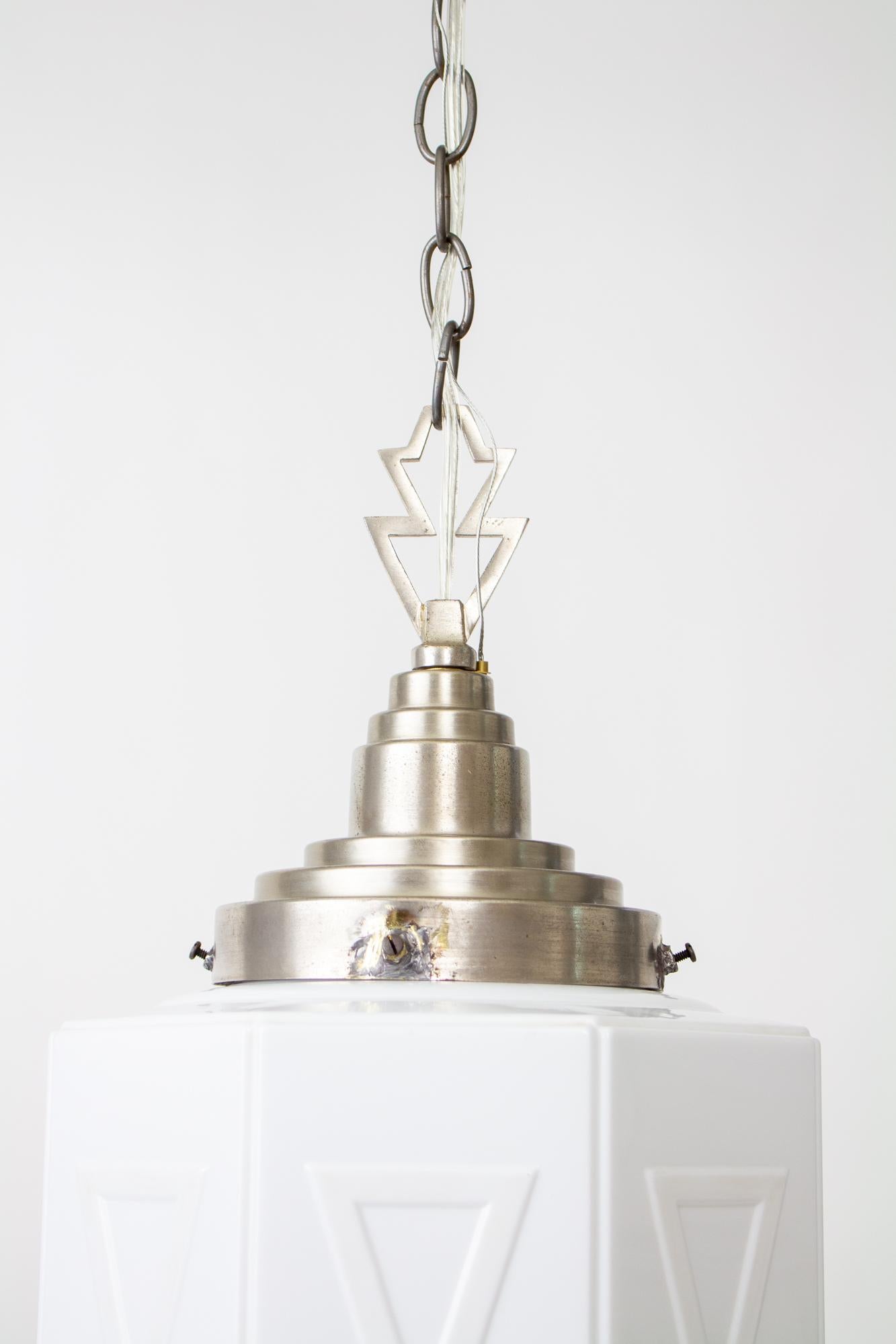 Pendentif géométrique en verre au lait Art Déco des années 1930. Luminaire en nickel brossé avec une seule ampoule à base standard. La longueur de 28