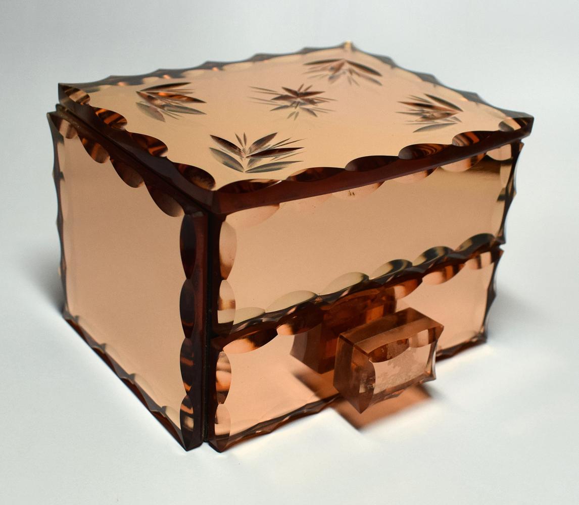 For your consideration is this very charming Art Deco Jewellery box made from cut and bevelled Peach mirror glass. It originates from France and is in very good vintage condition. The top opens up to reveal a silk linked interior which houses a
