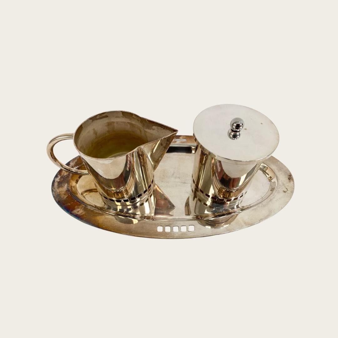 Cet ensemble de sucre et de crémier sur pied en argenterie italienne des années 1980 avec plateau a été créé par Richard Meier pour Swid Powell. L'ensemble, vendu ensemble, présente une bordure carrée perforée et une marque de créateur sur la face