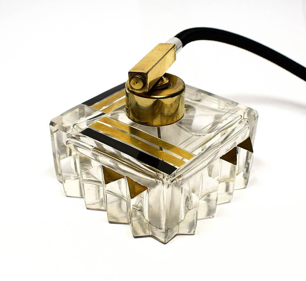 Beautiful and very collectible Art Deco perfume atomizer dating from the 1930s. French in origin. Square in shape with corrugated edging bottle in clear cut-glass glass with gold and black enameled geometric designs, quite stunning.
Gold toned metal