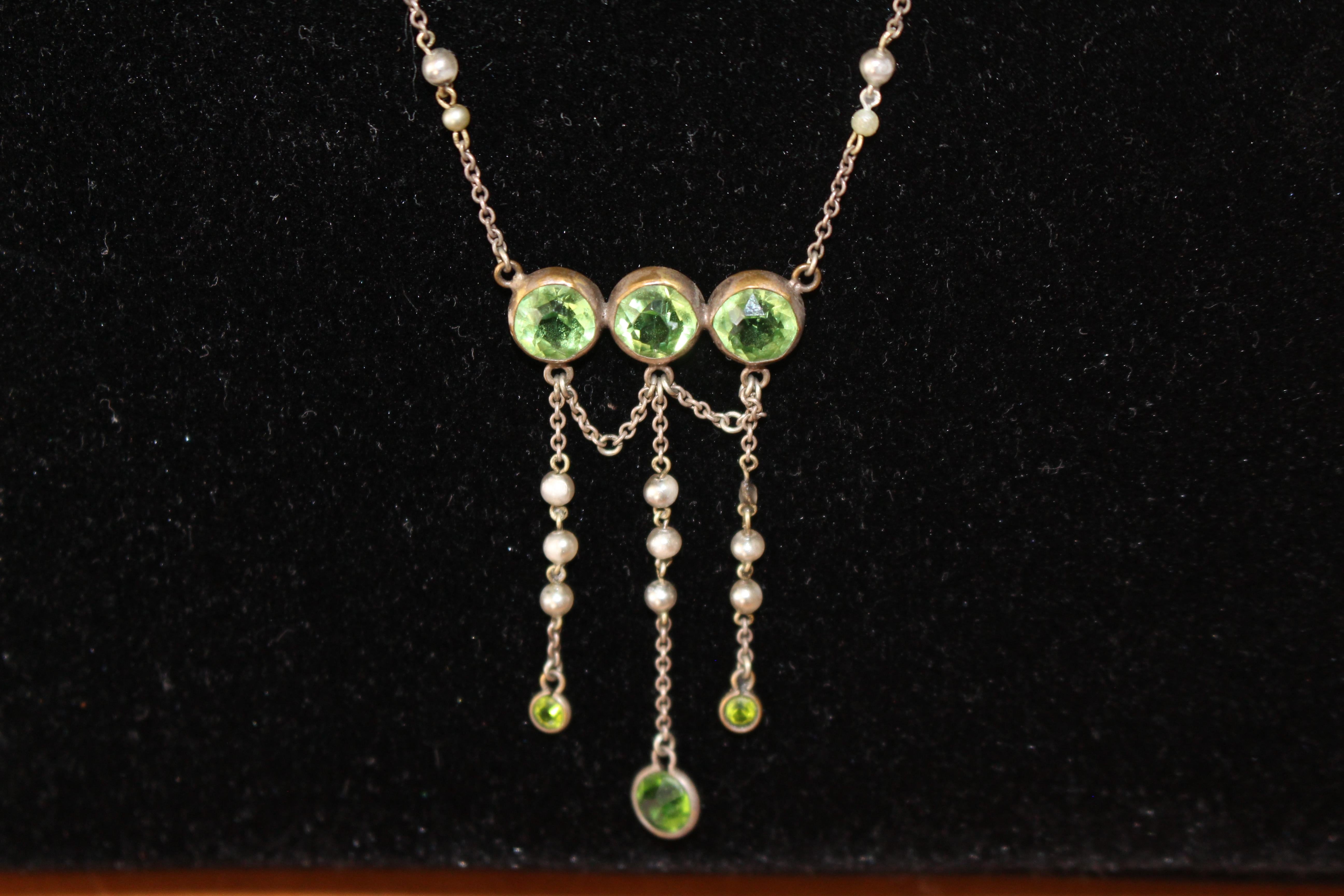 Very feminine and finely detailed pendant original to the Art Deco period with bright and clear peridot gemstones and pearls.

Total length of chain round the neck is 43 cms.

Condition:
Lovely condition.

Delivery:
Free delivery in the