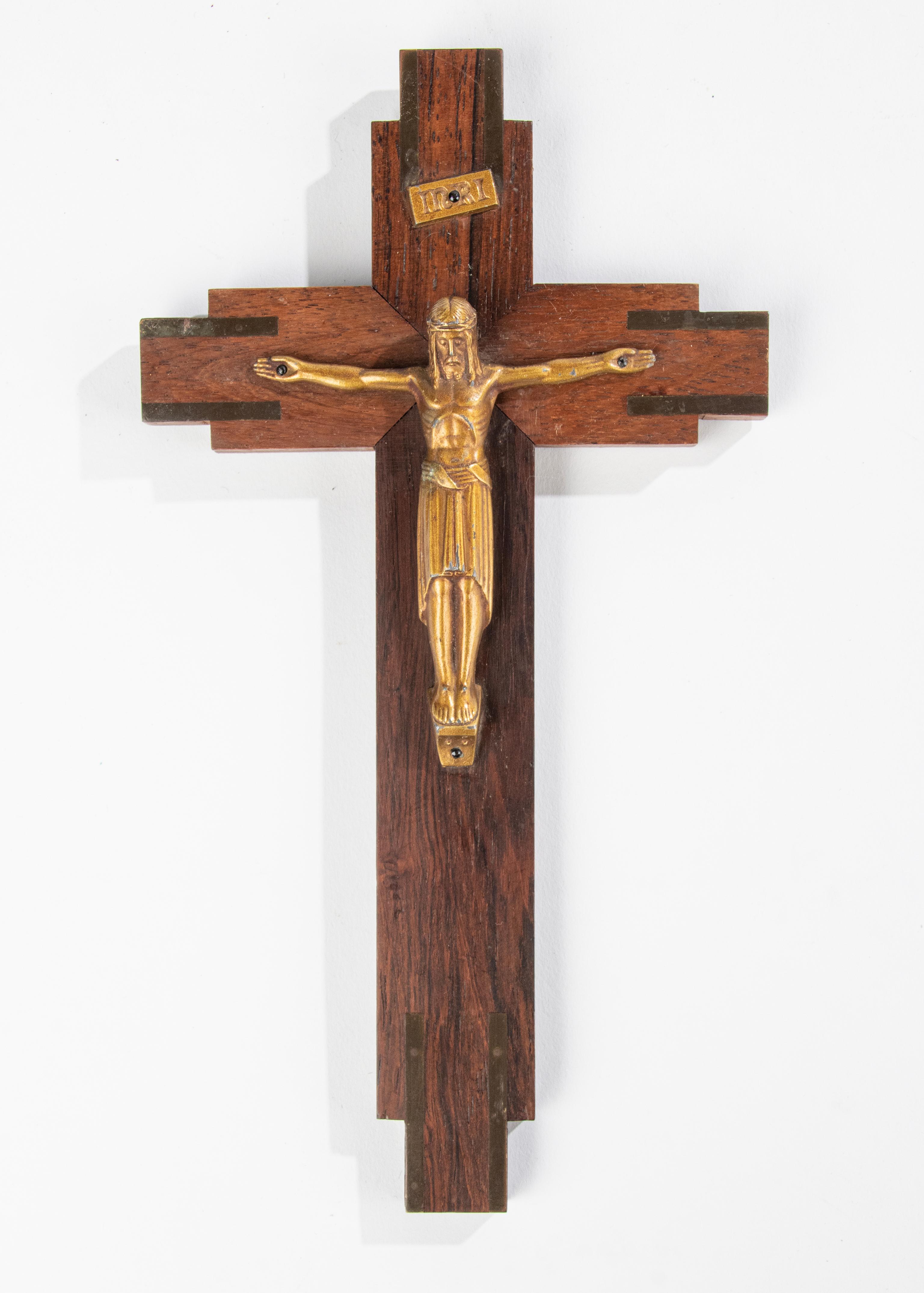 An Art Deco period Corpus Christi cross. The Jesus figurine is made of gilt spelter. The cross is made of solid rosewood with unpolished brass inlays at the ends. In good condition. 

