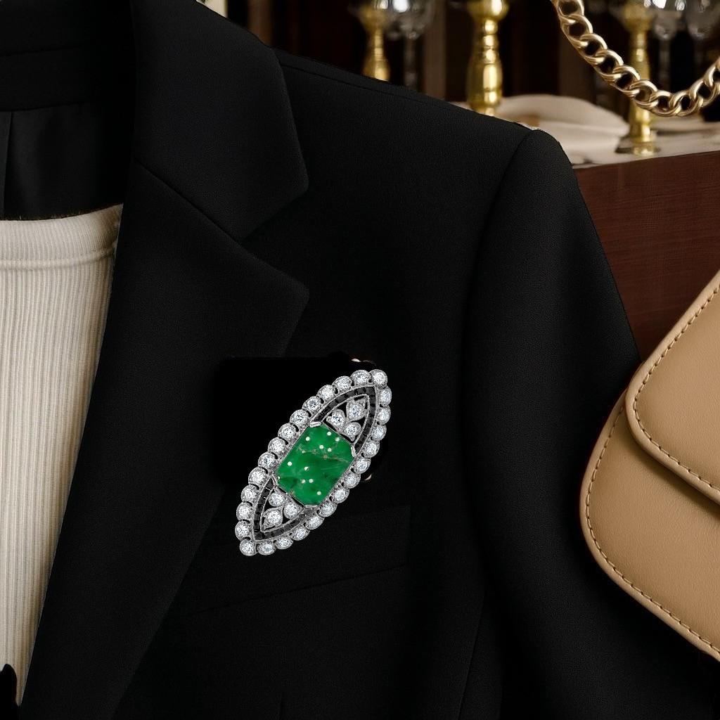 An exquisite example of Art Deco elegance and master craftsmanship, this circa 1930s platinum brooch encapsulates the glamour, geometry, and symbolic richness of the era. At its heart lies a translucent, finely carved jadeite jade, adorned with a