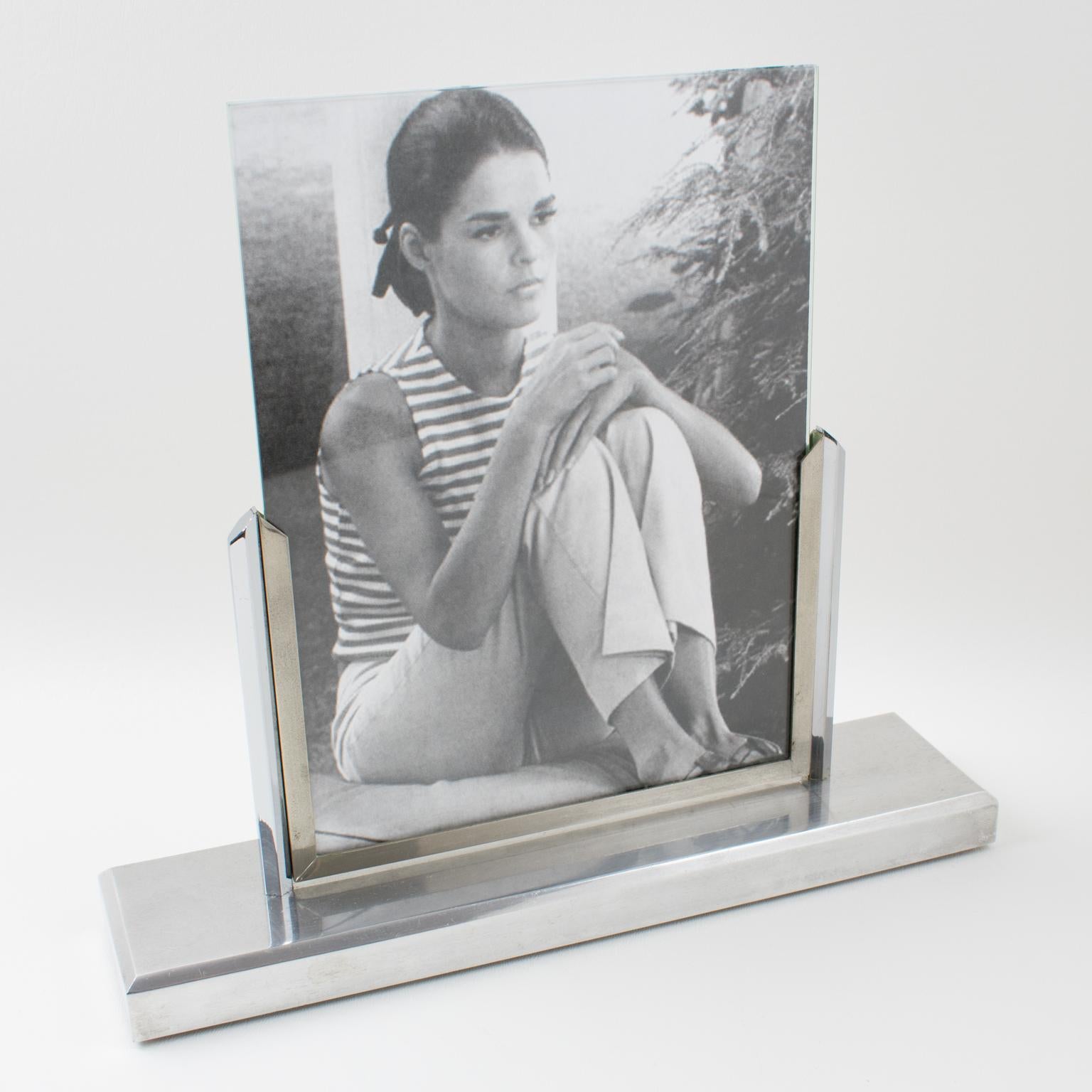 Lovely French Art Deco picture photo frame. Architectural polished aluminum shape with a raised rectangular base and two vertical frame-holders with swing support. The two supports hold two glass sheets that can hold a photo or image.
