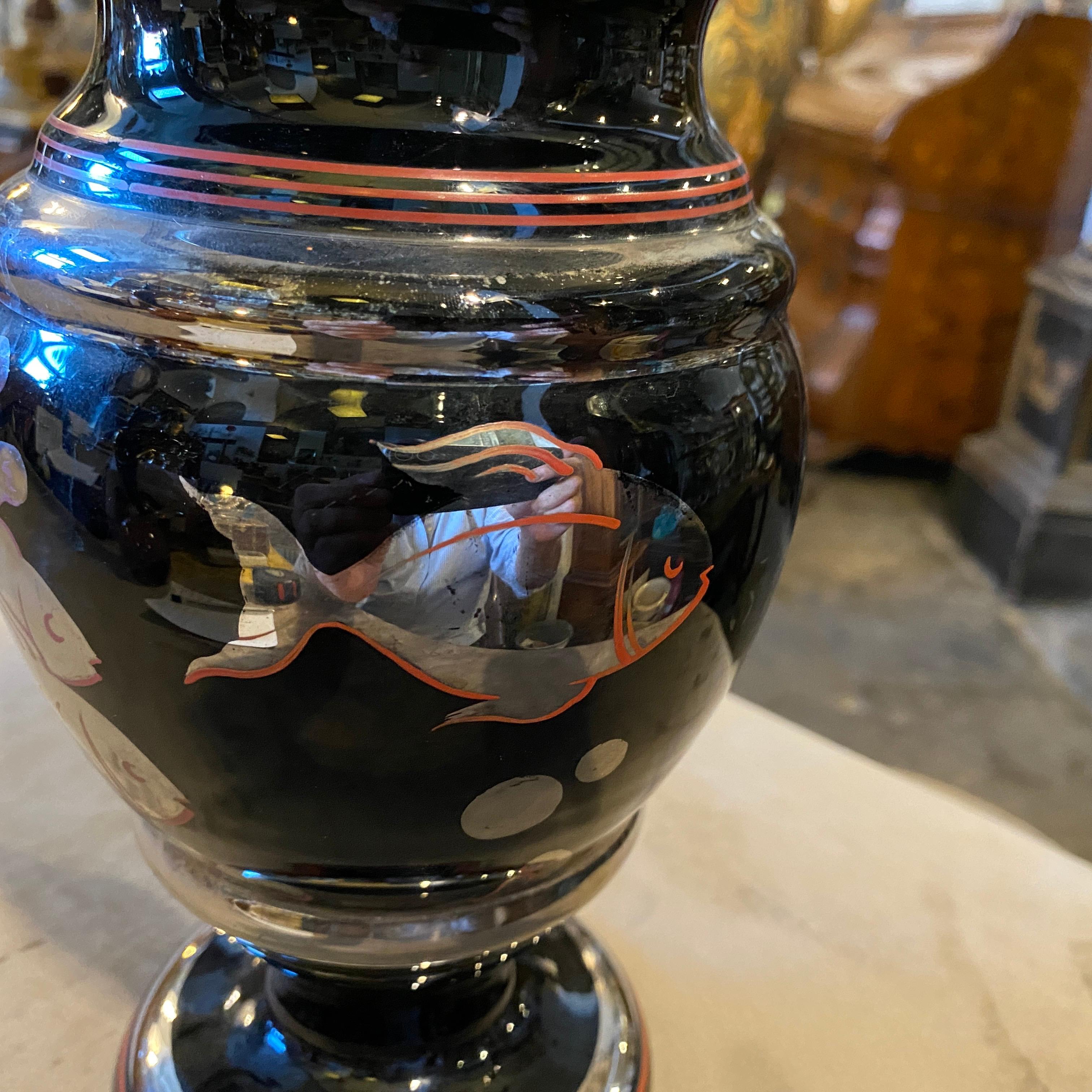 A rare art deco italian black glass vase decorated in red and silver with marine flora and fauna, it's in perfect conditions. This Italian vase is a captivating and luxurious piece of decorative art. It embodies the essence of the Art Deco style,