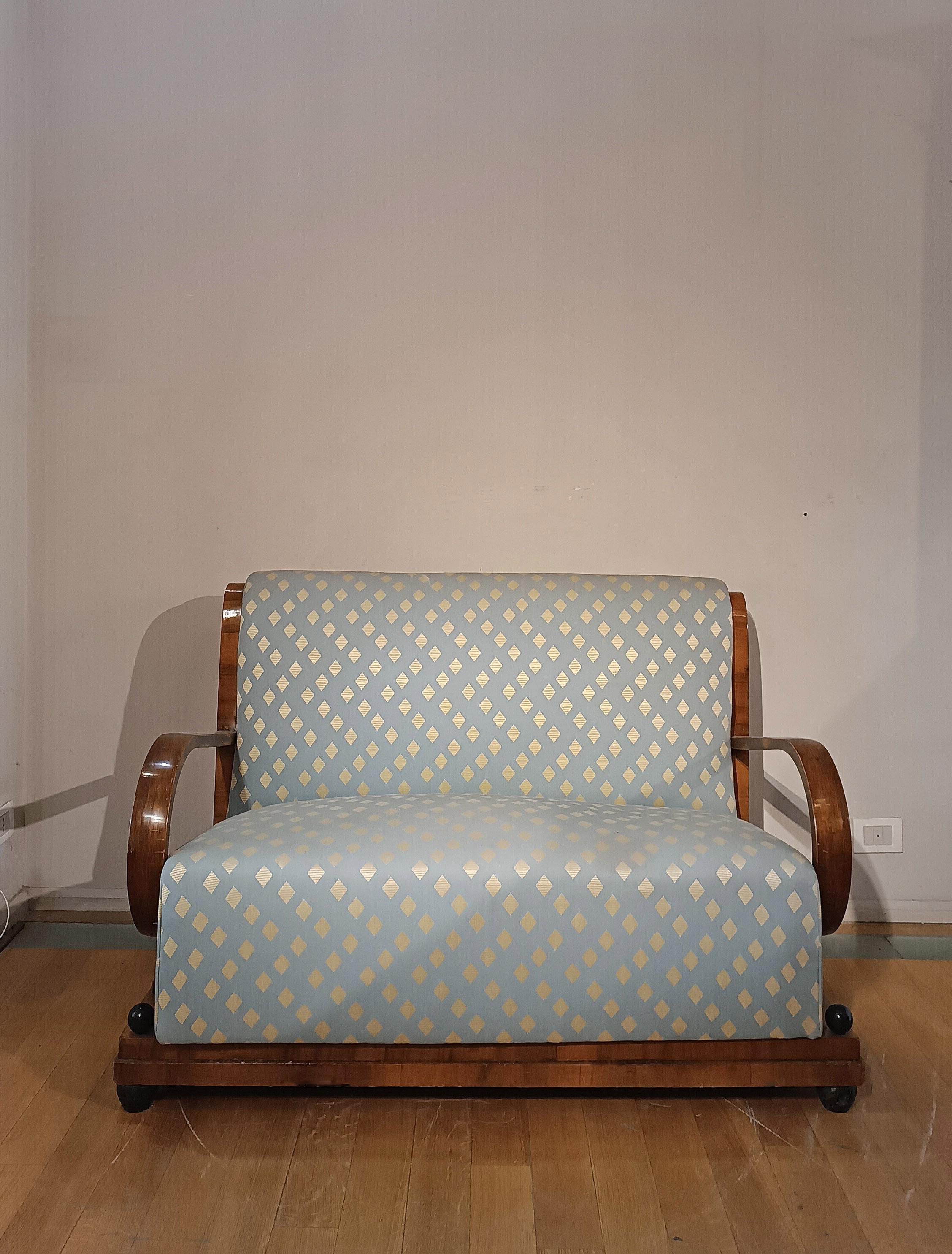 Espléndido sofá art déco chapado en nogal, con adornos y pies ebonizados. Acolchado con suspensiones de muelles y tapizado en tela azul claro con rombos blancos, este sofá presenta un respaldo curvado y brazos arqueados que le confieren un diseño