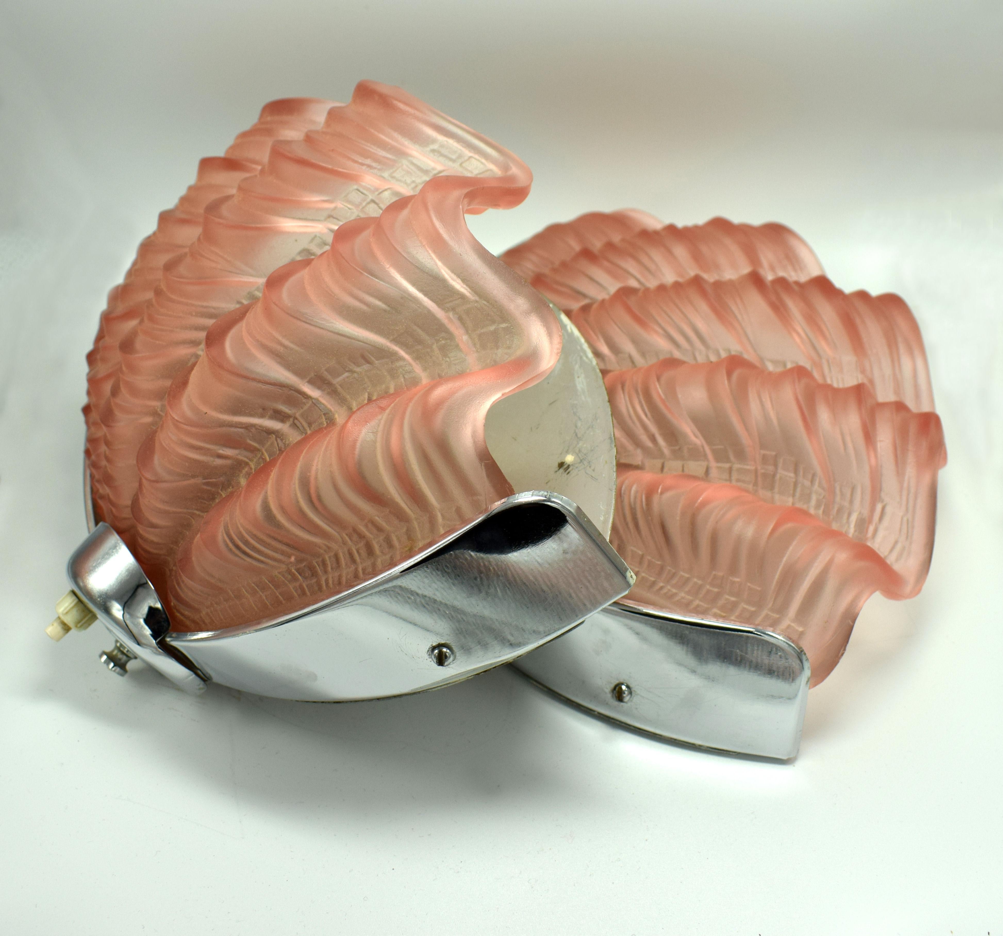 A beautiful matching of Art Deco wall lights of shell form. The chrome frames are in very good original condition which when fitted to the wall hold the beautiful soft pink shades firmly in place. Truly beautiful and will work perfectly with the