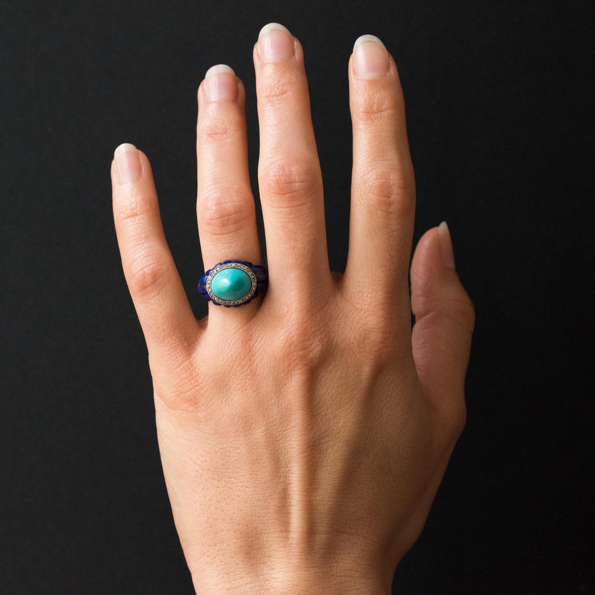 Ring in platinum.
Lovely domed art deco ring, it is adorned on its top with a sugar loaf turquoise surrounded by rose- cut diamonds, and adorned all around with lapis lazuli cabochons.
Total weight of the turquoise : approximately 6.90