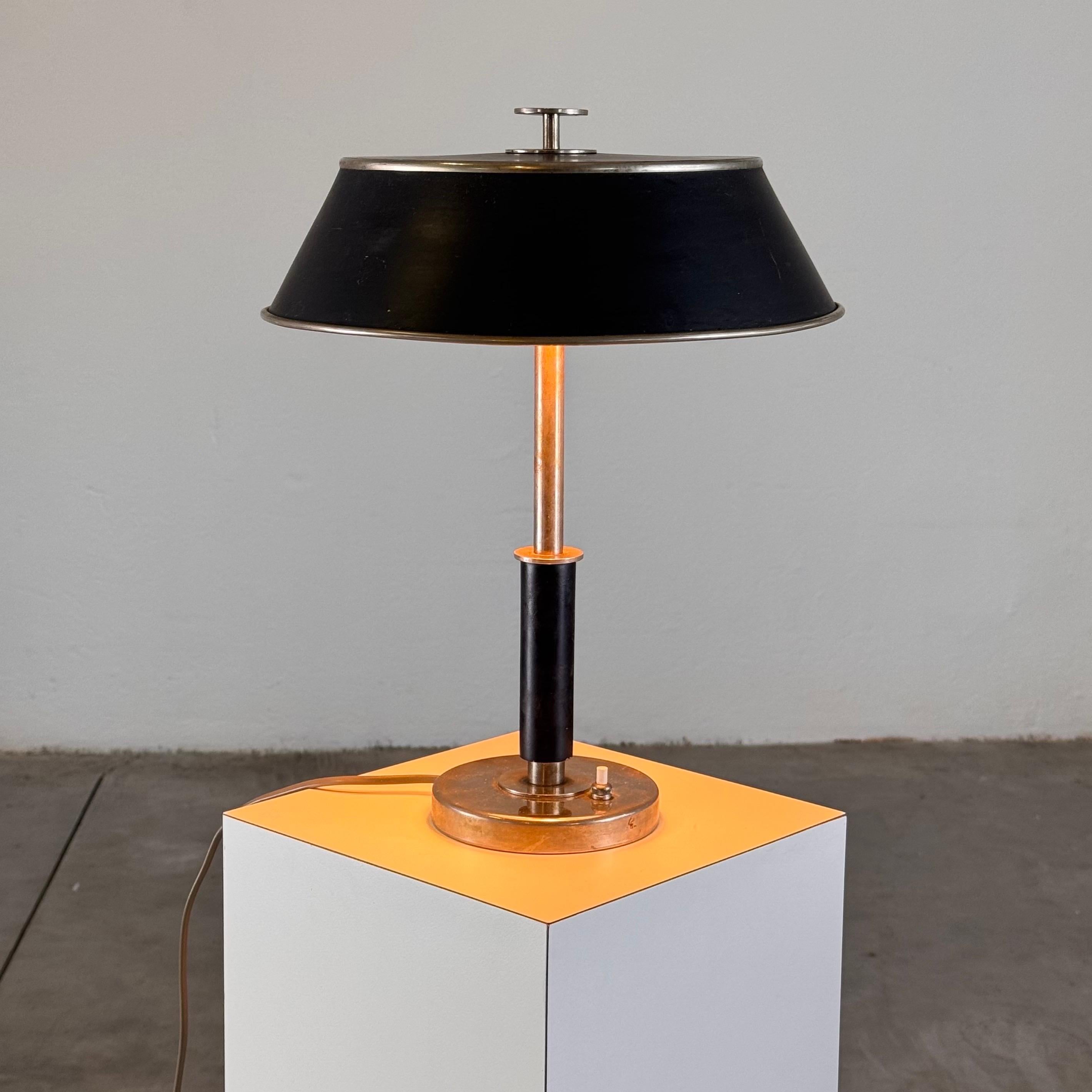 A stunning 1930s table lamp by Erik Tidstrand, produced by the esteemed NK Nordiska Kompaniet. This exquisite piece blends the sophisticated lines of Art Decò with the refined simplicity of Swedish Grace, exemplifying the craftsmanship of one of