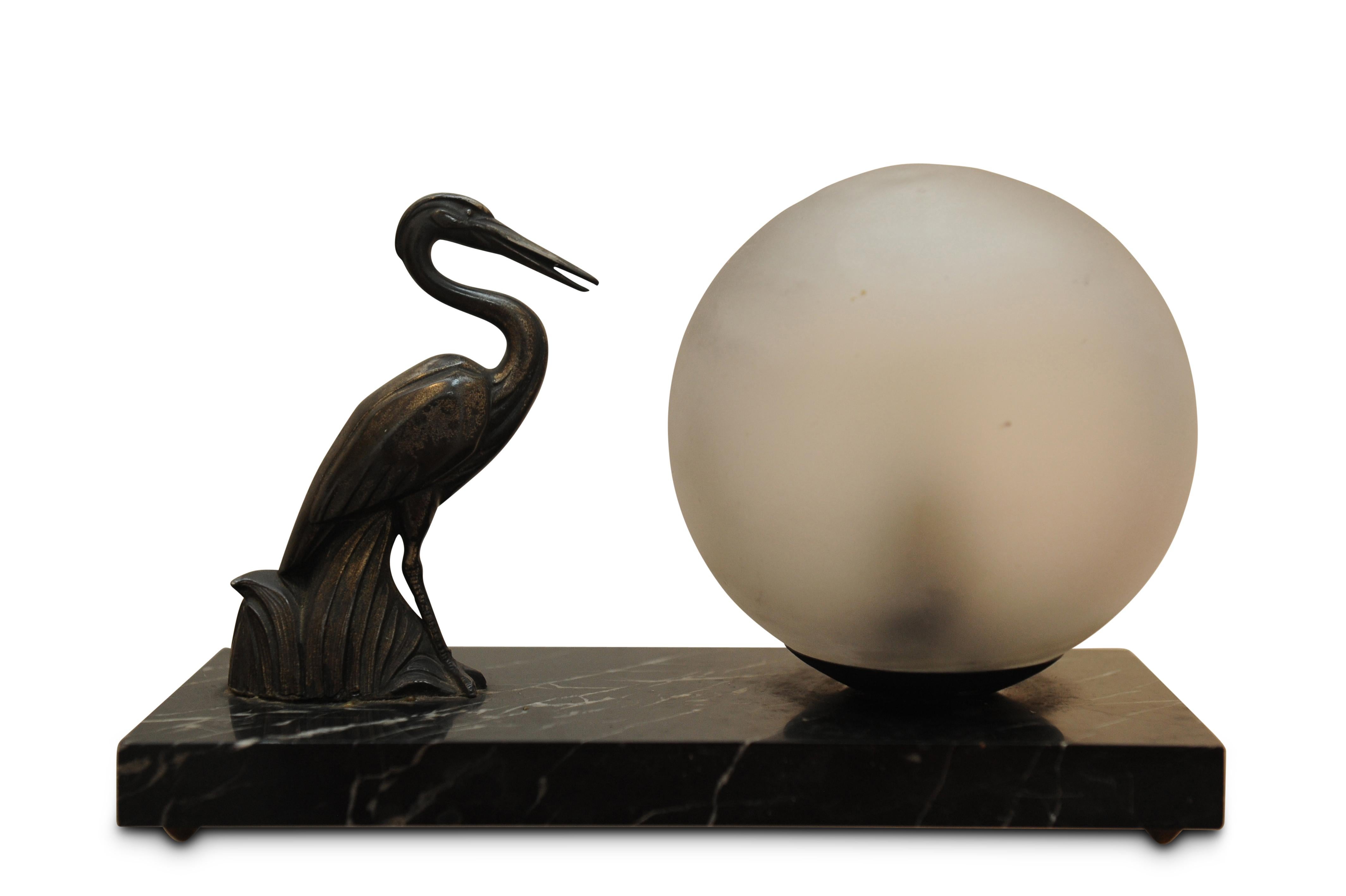 1930s Art Deco table lamp Spelter sculpture of a heron with a glass globe on a marble plinth.

Working and will be fitted with the appropriate plug fixture. No cracks or chips to marble or glass globe only chipping is to base of globe that will