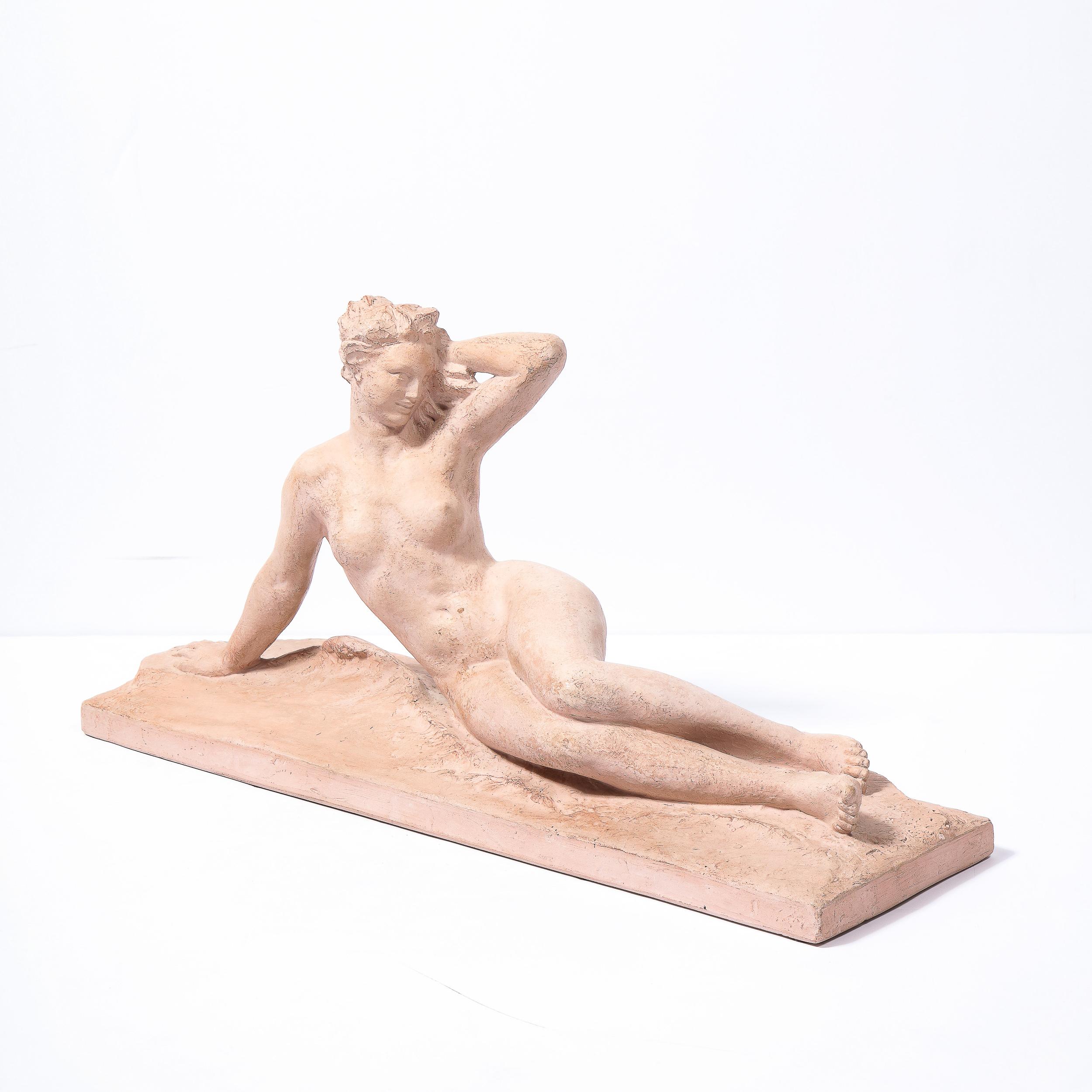 This refined and sophisticated Art Deco statue by Henri Bargas was realized in the France, circa 1930. Composed exclusively of terracotta- in a beautiful chalky, earthy red tone- the work offers a stylized nude female form recumbent on an undulating