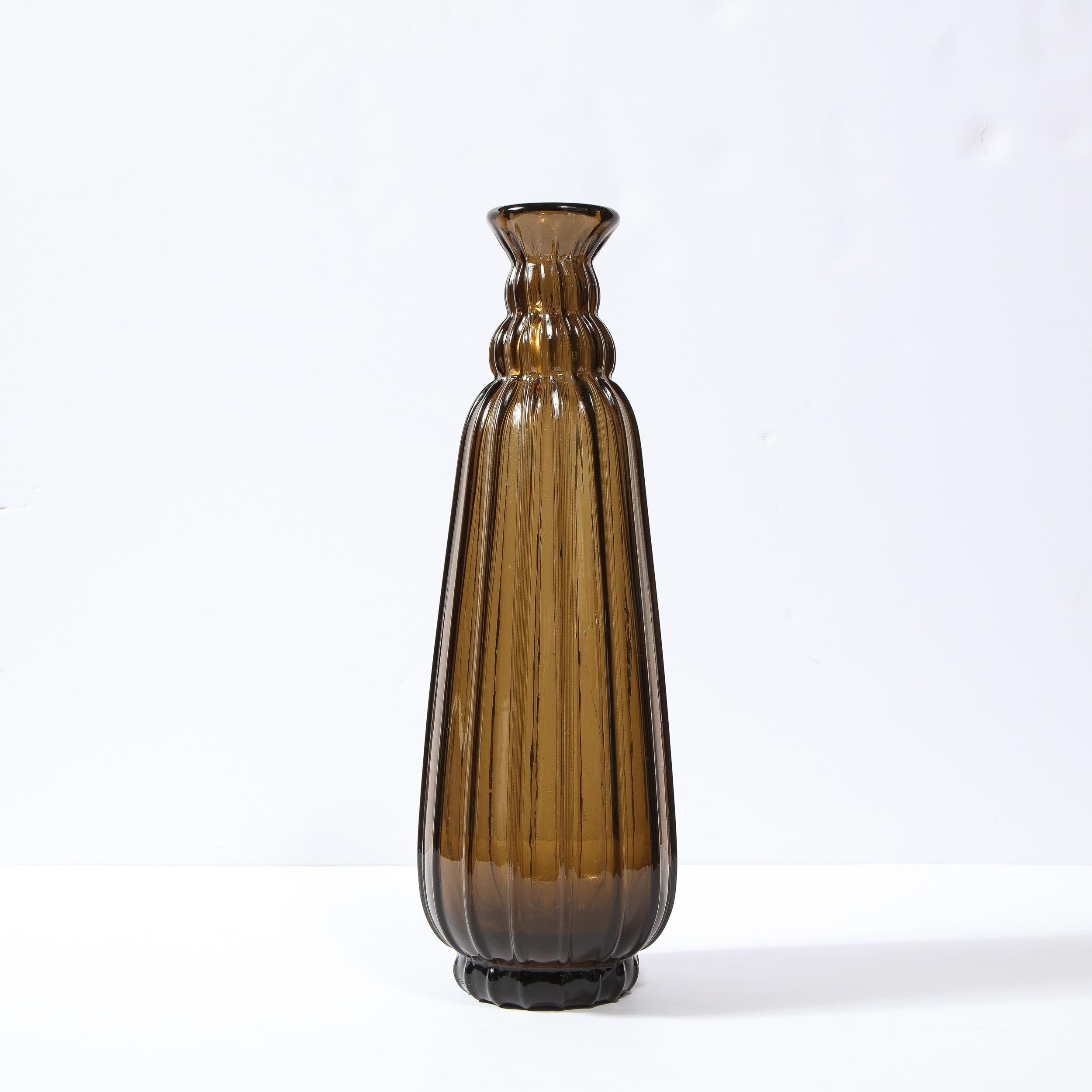 This outstanding topaz and museum quality French Art Deco hand blown glass vase by Daum studio is features vertically equidistant repeating striations tapering to a narrow neck. This elongated shaped vase was realized in Circa 1935. The vase or