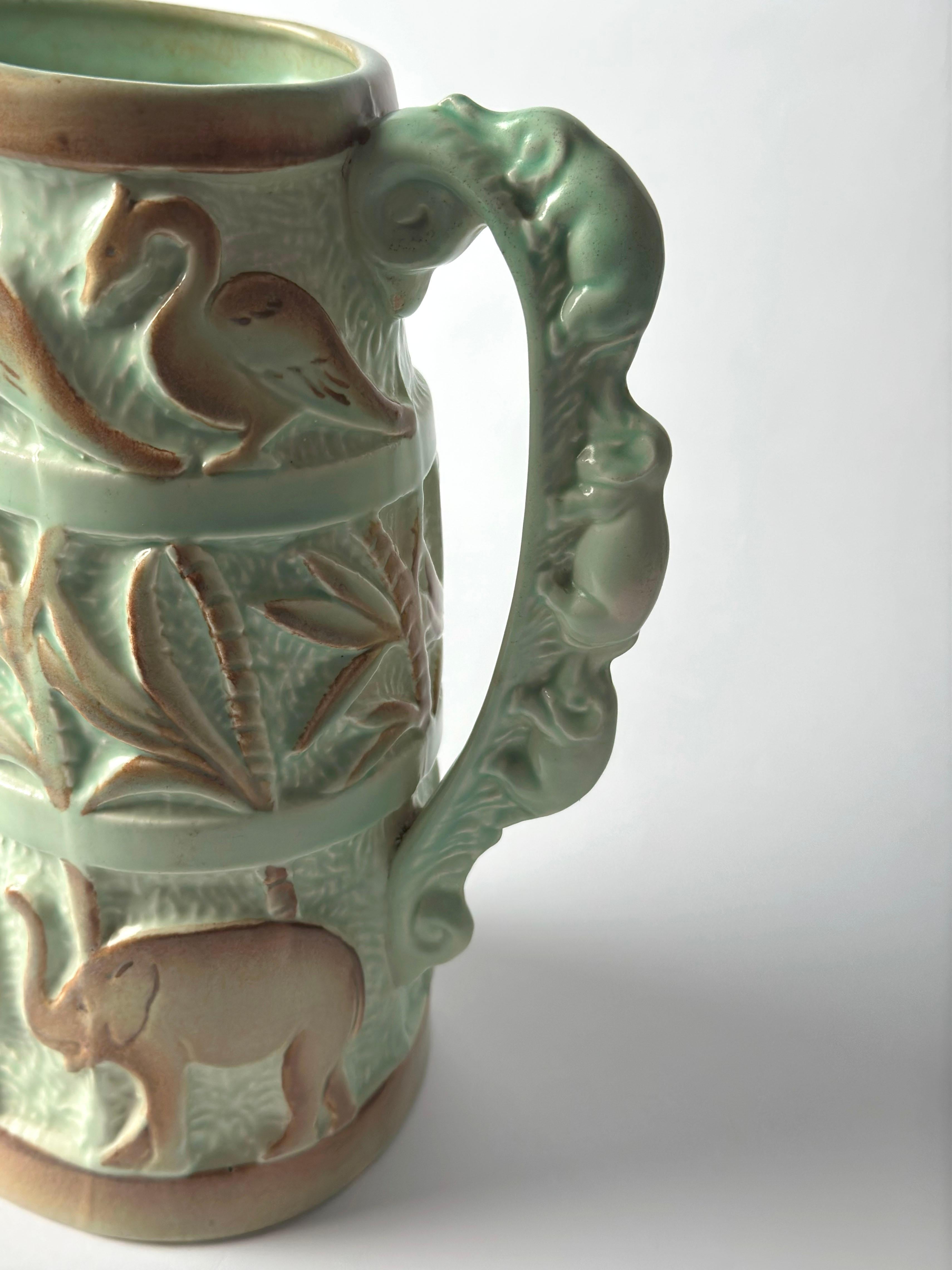 A highly decorative Art Deco ceramic jug by Burleigh Ware, produced by Burgess & Leigh in England around the 1930s. This striking example of tropical revival style merges bold form with detailed relief work, capturing the era’s fascination with