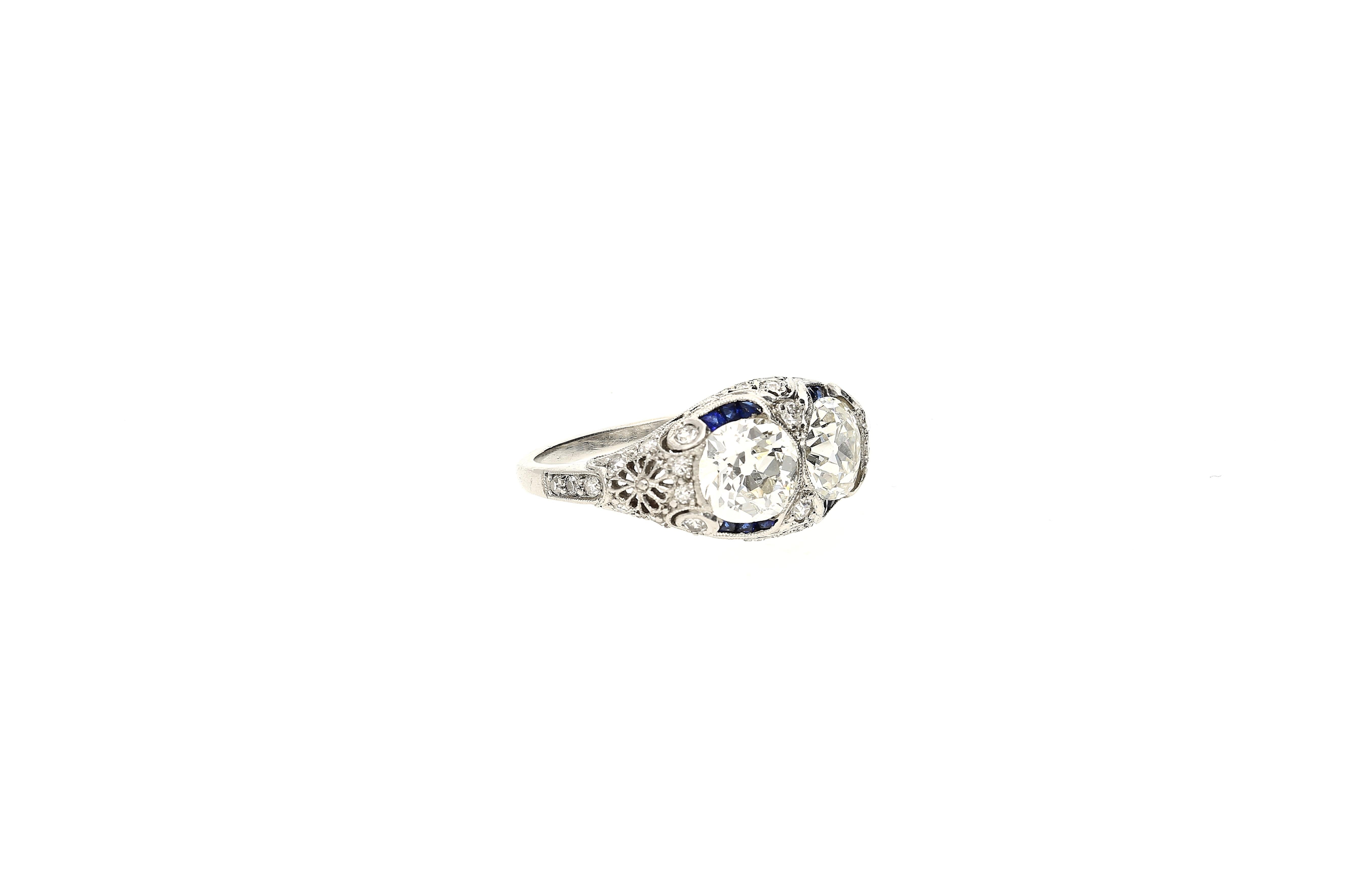 Original 1930's Art Deco vintage double diamond ring with additional diamond and sapphire adornments. This ring is almost 100 years old and in mint condition. An incredible feat considering the ring's antiquity. 

2 perfectly matched diamond center