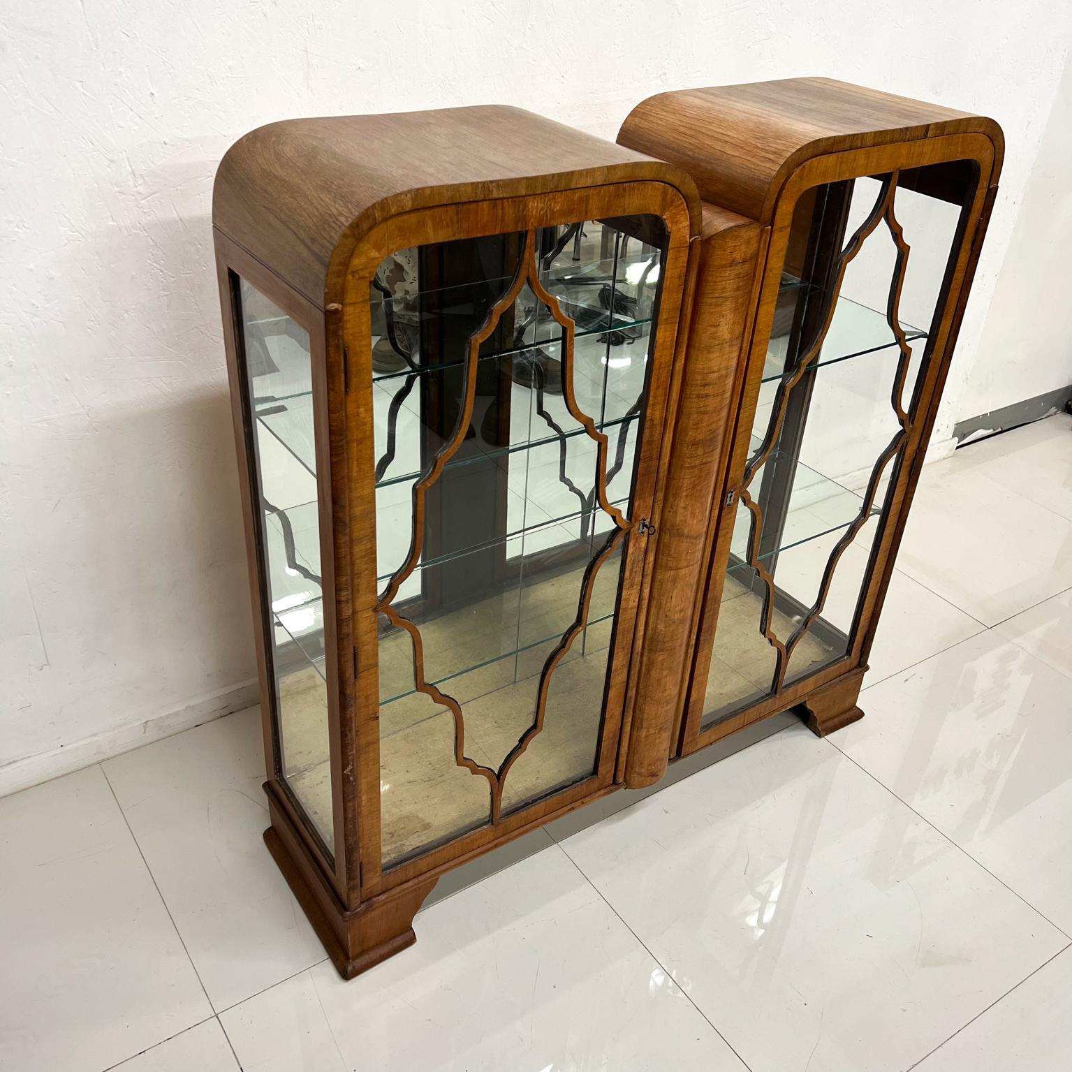 1930s Art Deco Display cabinet exotic wood vitrine with bent plywood.
Two doors with original glass panels lead back frame.
Sculptural wood details at front.
Two glass shelves, original key present and in working condition.
Measures: 45.5 tall x