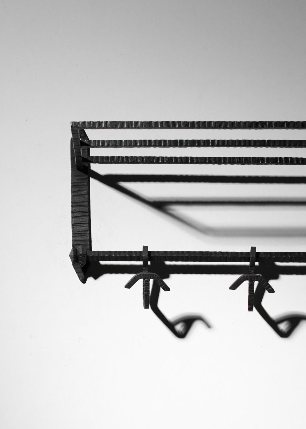 French Art Deco wall-mounted coat rack from the 1930s. Entirely made of black lacquered wrought iron, with three hooks and a shelf on top. Very good vintage condition, with slight signs of age and use (see photos).
