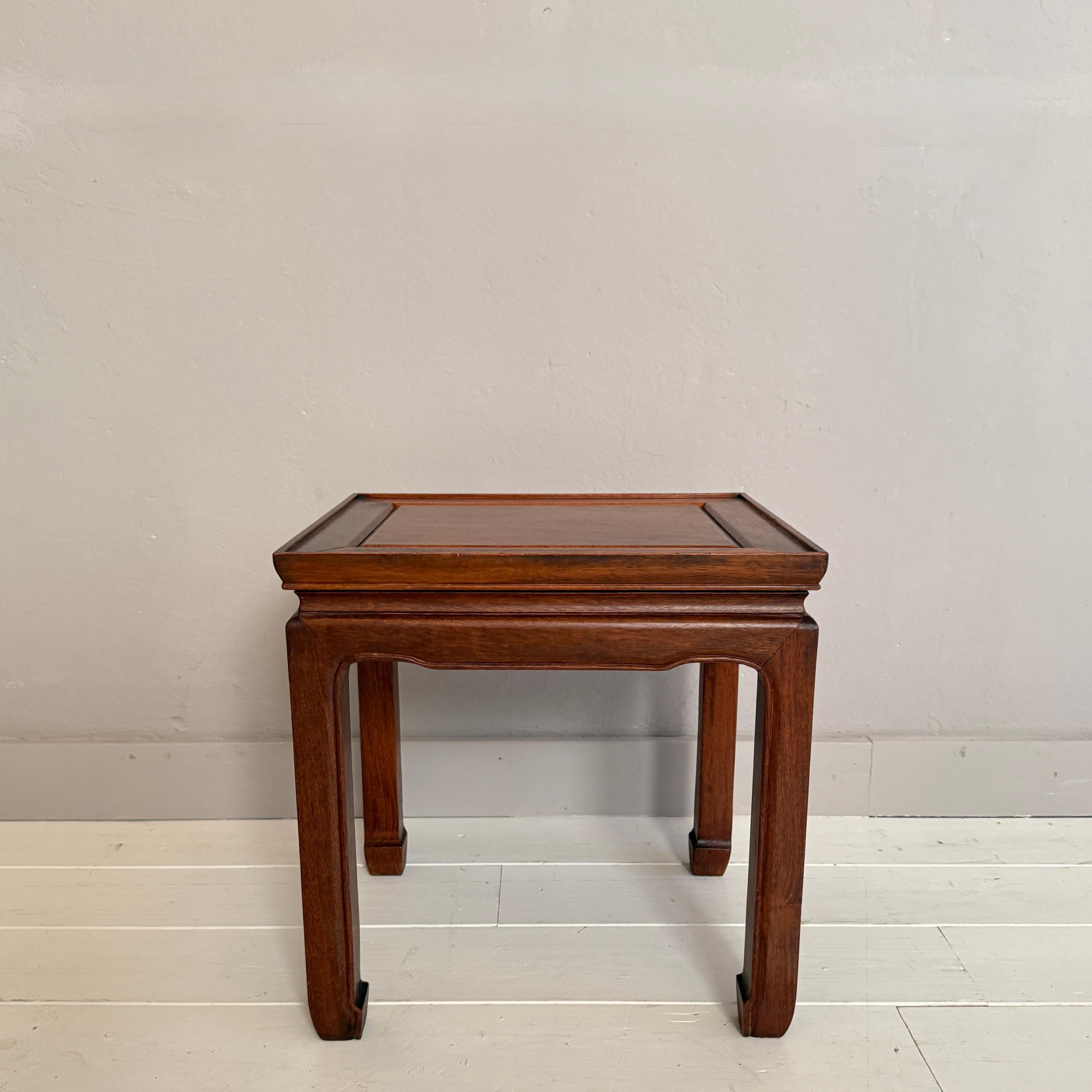 This elegant Asian side table from the 1930s embodies refined craftsmanship and timeless simplicity. Made from richly toned hardwood, the piece features a beautifully shaped apron and subtly curved legs that reflect traditional Chinese design