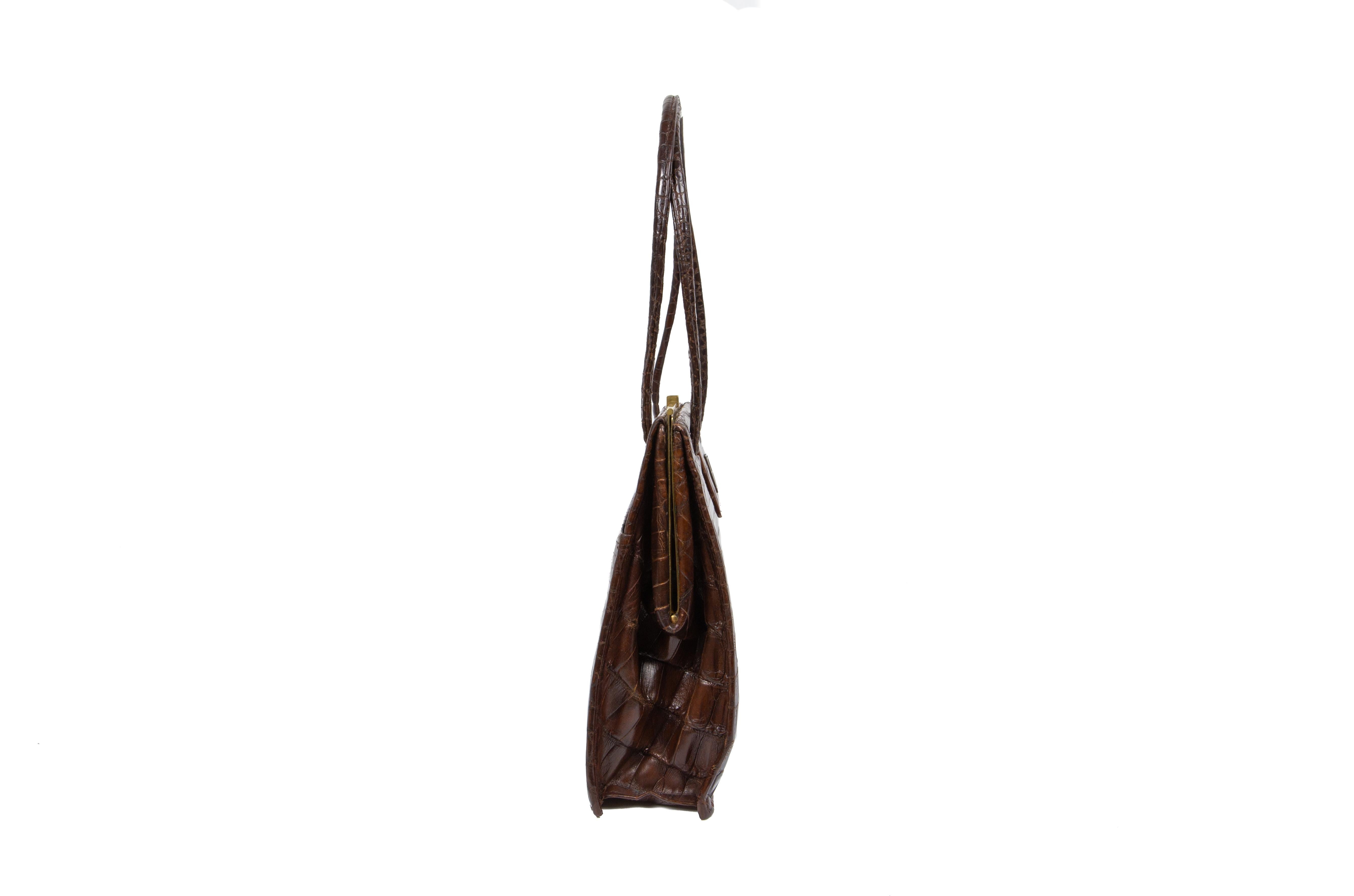 A typical late 1930s Asprey sienna-brown crocodile handbag, comprising of one compartment with one gusseted zipper pocket, two patch pockets piped with chamois-brown leather, one lipstick holder and one outer back pocket, fully lined in an