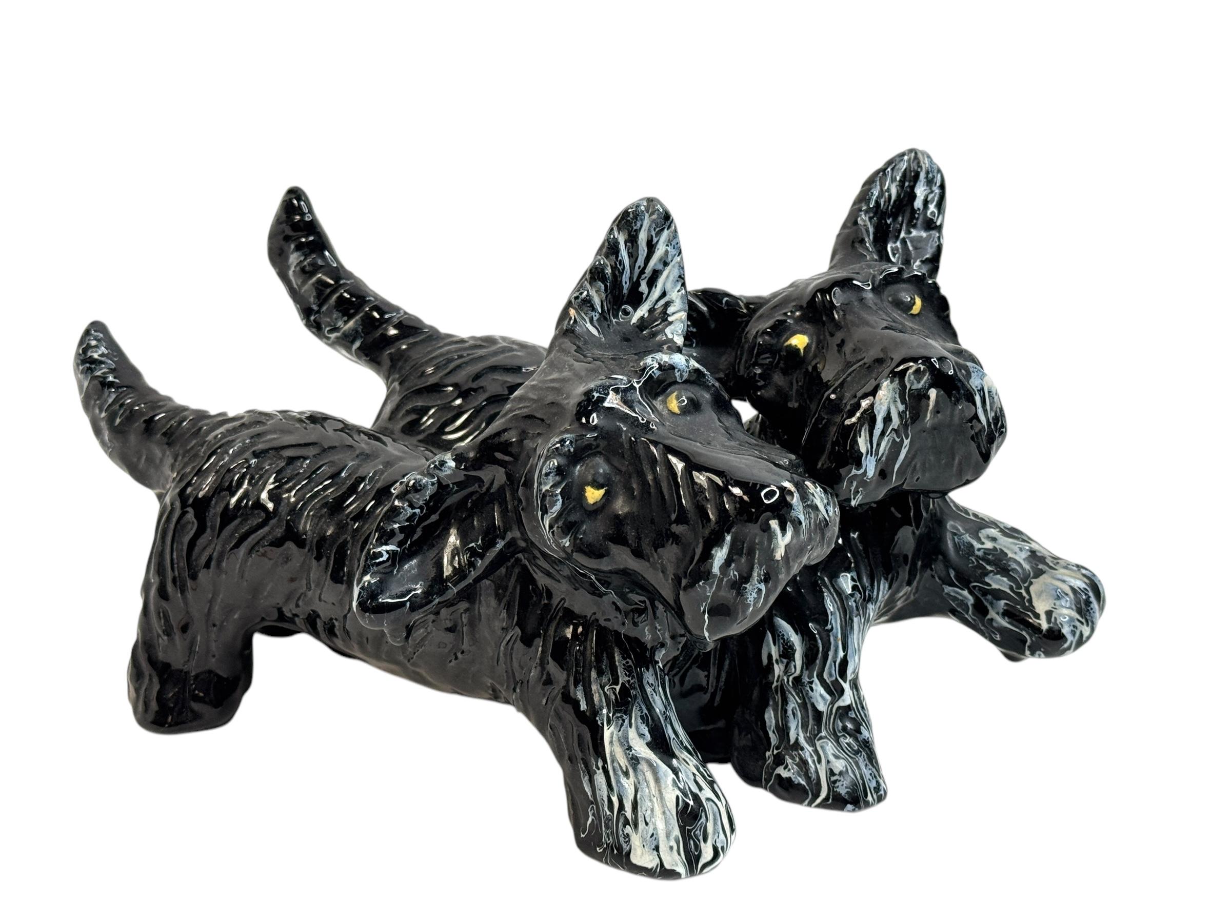 Graziosa statuetta in maiolica austriaca Goldscheider d'epoca raffigurante un cane Scottish Terrier.

Una statuetta nera degli anni '30 di Goldscheider Wien, una manifattura austriaca attiva dal 1885 al 1950. Il pezzo rappresenta due cani. Dettagli