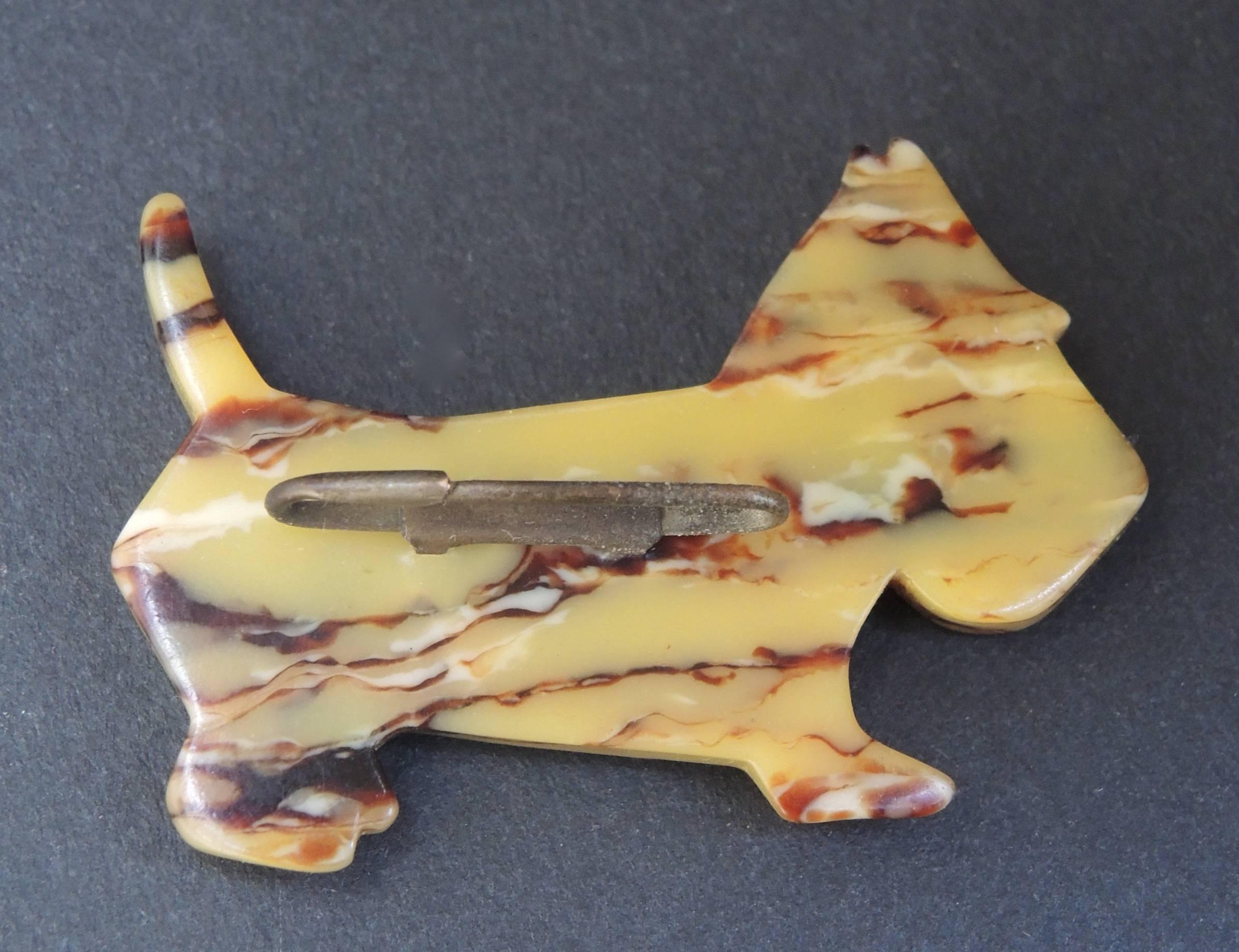 This iconic scottie dog pin made of tortoise coloured bakelite will match any ensemble. Completely original and ready to use on a daily basis. Pin it to your lapel or to a hat for a touch of vintage sophistication.