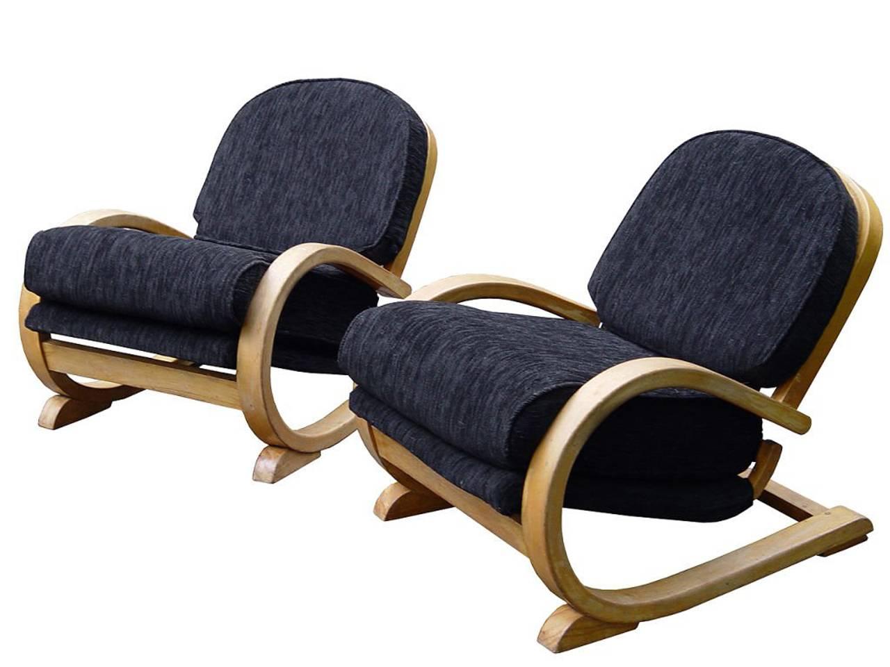 The modern design of these chairs were extreme for the 1930s. They sit very low and are quite comfortable. But you need to be under 40 to get out of them. They are striking as a pair and are unique in their posture and finish. The upholstery is new